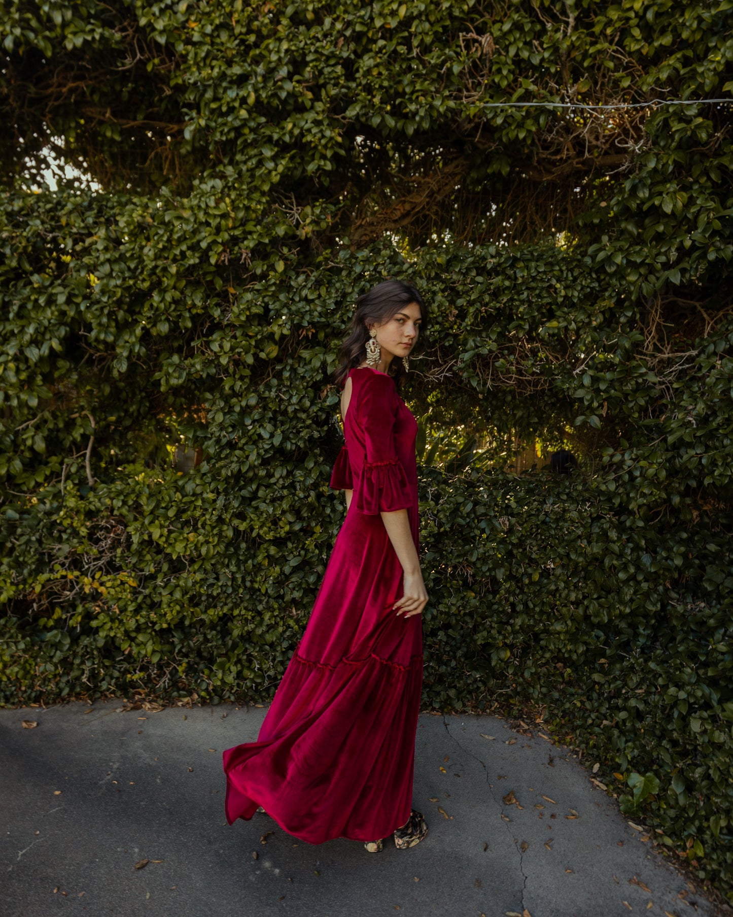 This deep red velvet sweetheart dress features bell sleeves and a full tiered ruffle skirt. With an optional sweetheart cut out in back, you can show off a little skin while still concealing your bra.