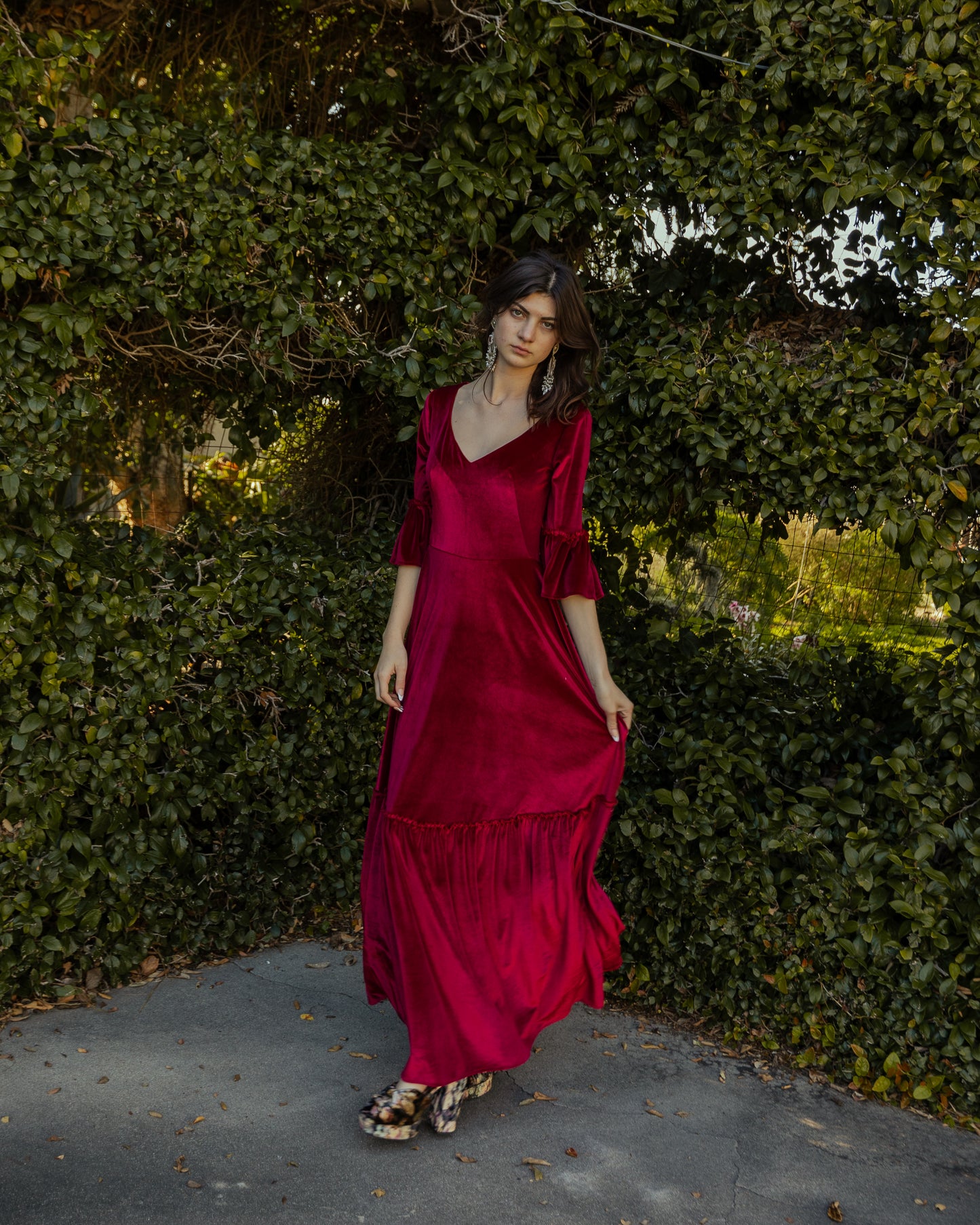 This deep red velvet sweetheart dress features bell sleeves and a full tiered ruffle skirt. With an optional sweetheart cut out in back, you can show off a little skin while still concealing your bra.