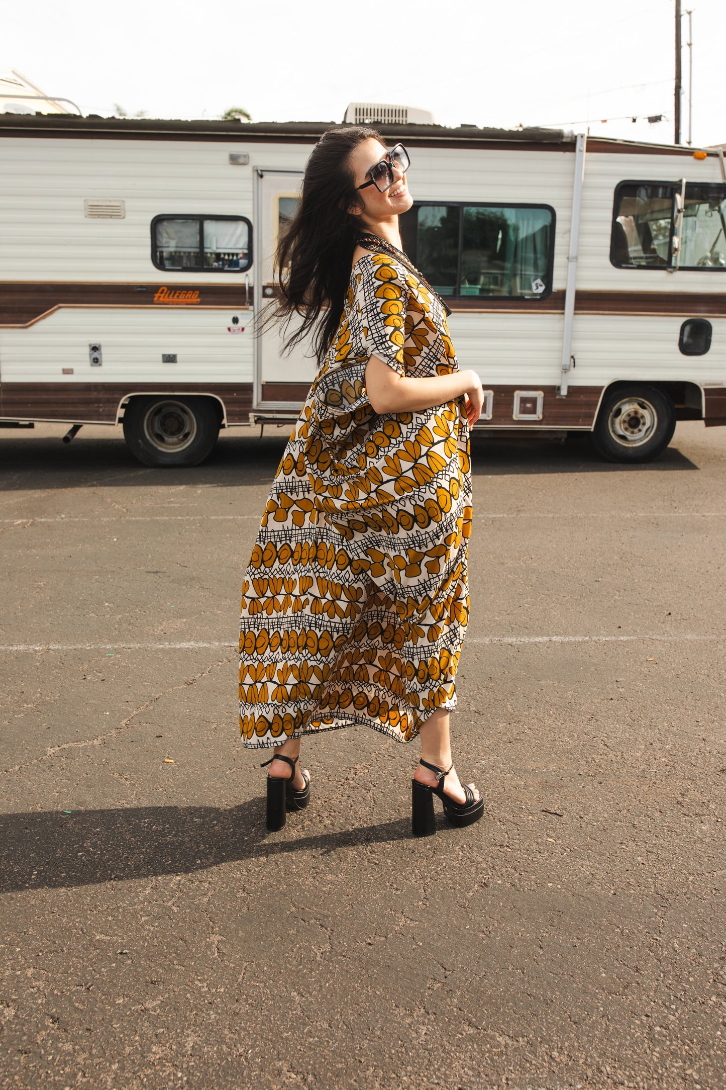 Full length retro patterned caftan. Vintage inspired with golden leaf-like pattern and black and white accent design. V-Neck style with batwing sleeves and ankle hem. 