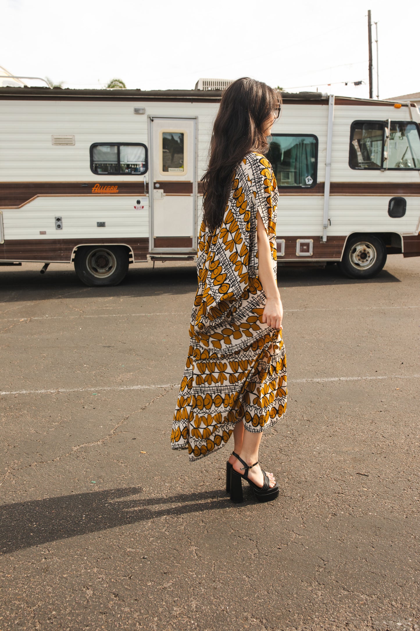 Full length retro patterned caftan. Vintage inspired with golden leaf-like pattern and black and white accent design. V-Neck style with batwing sleeves and ankle hem. 