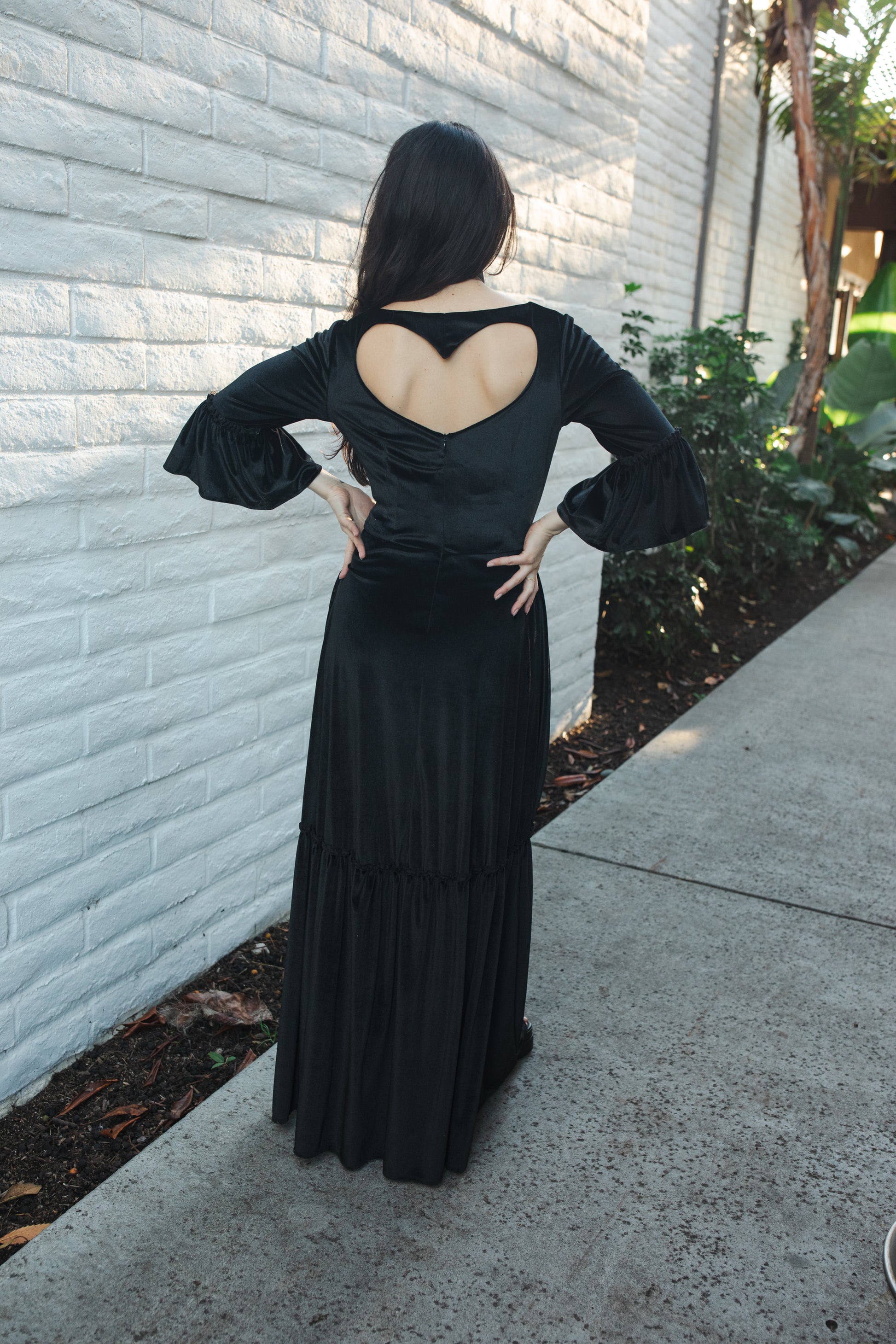 This black velvet sweetheart dress features bell sleeves and a full tiered ruffle skirt. With an optional sweetheart cut out in back, you can show off a little skin while still concealing your bra.  Ankle hem and v-neckline. 