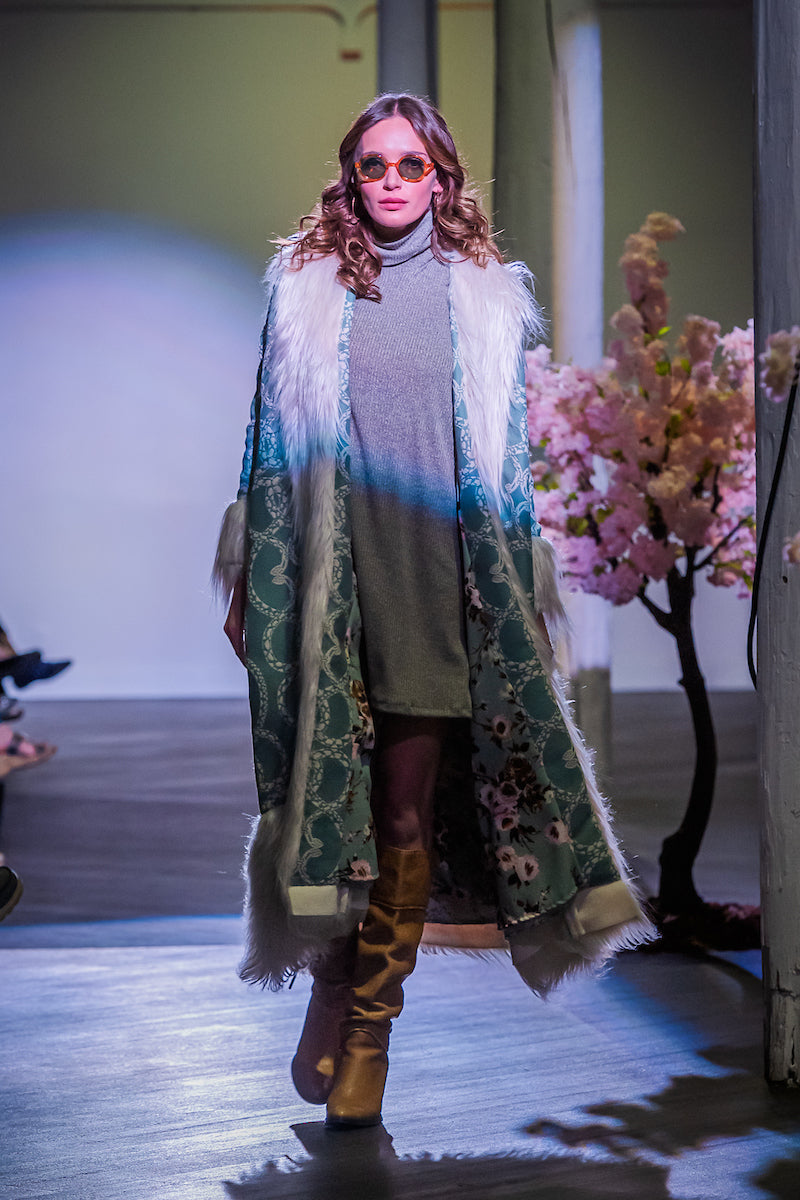 Long, penny lane style trench coat fashioned from a thick, mint green fabric embroidered with ivory snakes. Embellished with long ivory faux fur along collar, lapel, cuffs, and hem. Contrast floral lining. Bohemian maximalism in style.
