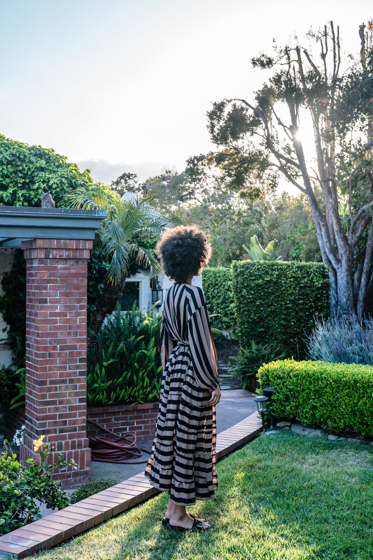 A coffee colored striped ruffled maxi dress. Featuring thick black and brown café stripes, long sleeves, ankle hem, full length button down in front, and optional belt to cinch the waist.