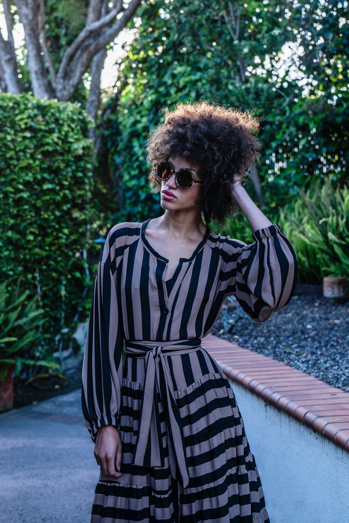 A coffee colored striped ruffled maxi dress. Featuring thick black and brown café stripes, long sleeves, ankle hem, full length button down in front, and optional belt to cinch the waist.