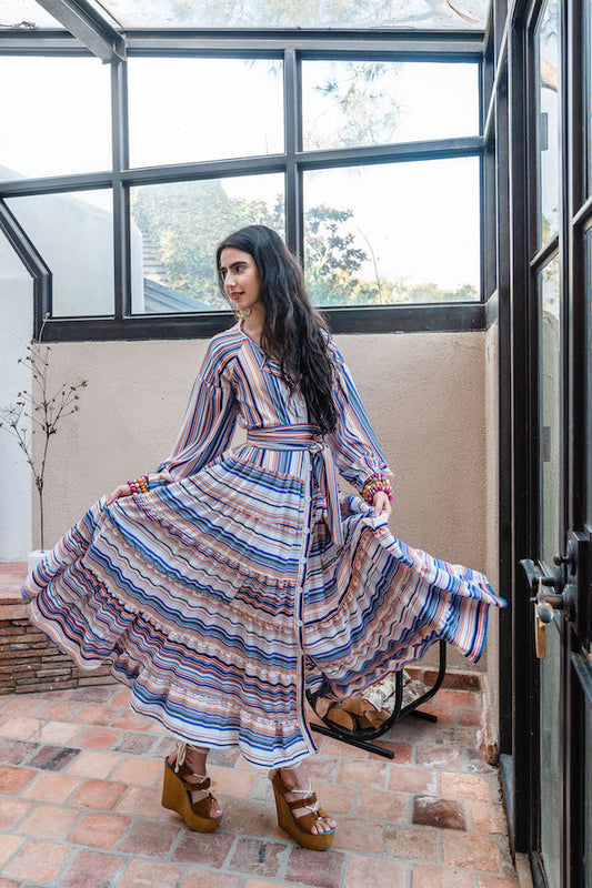 This elegant maxi dress features vivid banner of blue, white, yellow, and salmon stripes in a vertical pattern on the top half, and horizontal pattern on the lower half of dress. With long balloon sleeves, boat neck, full button down the middle, ankle length hem, and detachable waist wrap making this maxi both chic and versatile.