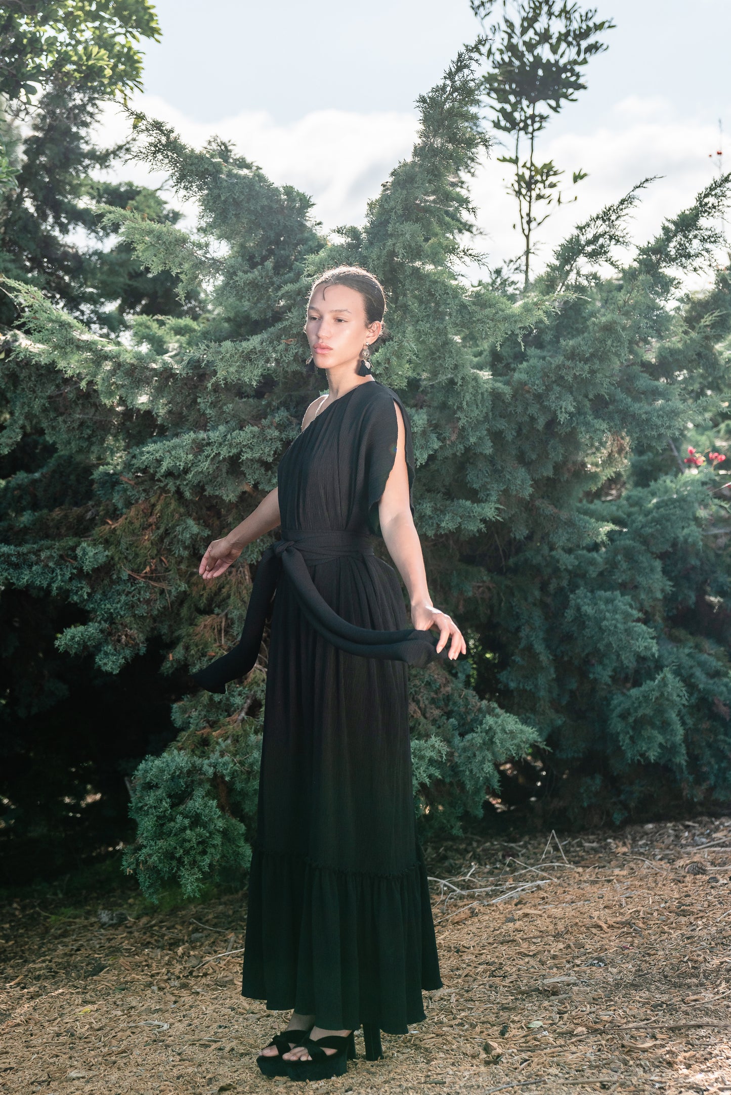 Effortlessly elegant, the Black Diamond Pleated Maxi Dress features a flattering one shoulder design with a long Obi style belt. The pleated details and shimmering sequins add texture and movement, while the flared silhouette and ruffle hem create a feminine and sophisticated look.