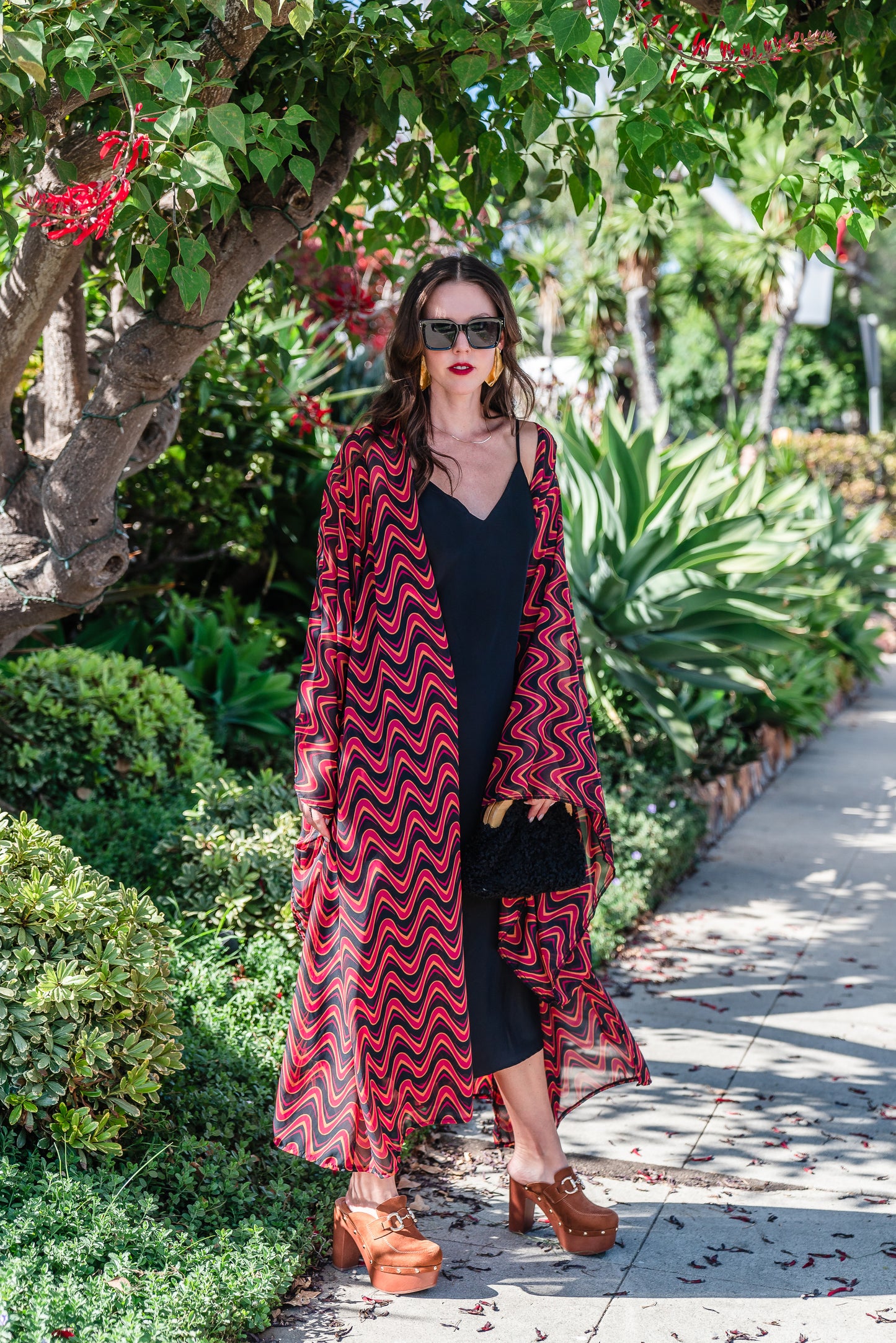This Kimono features a futuristic spiral print in striking black and red, with a pop of orange for a modern and elegant touch.