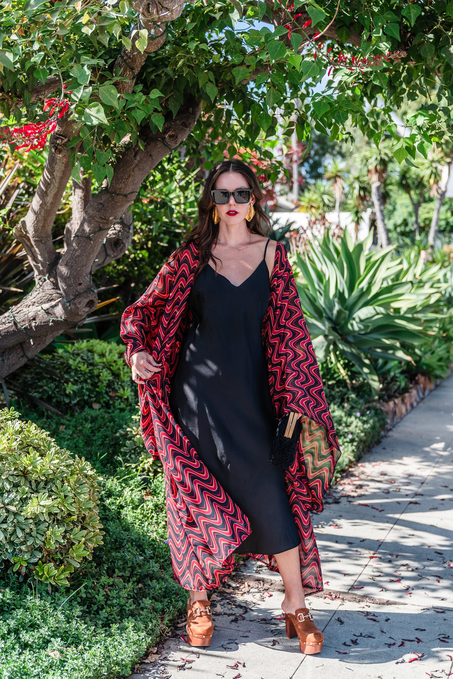 This Kimono features a futuristic spiral print in striking black and red, with a pop of orange for a modern and elegant touch.