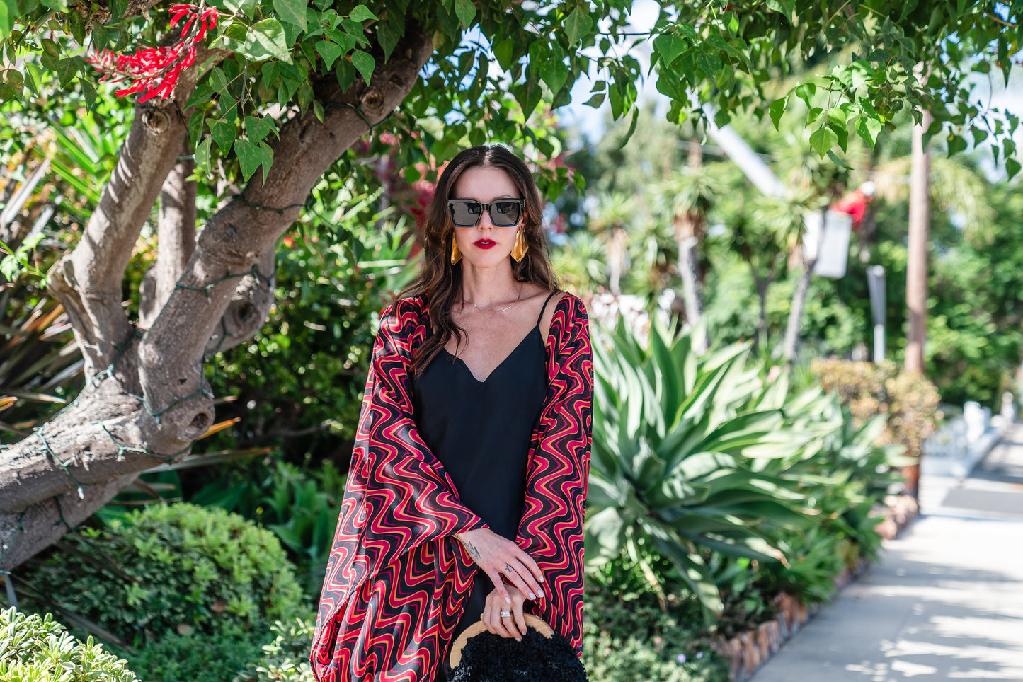 This kimono features a futuristic spiral print in striking black and red, with a pop of orange for a modern and elegant touch.