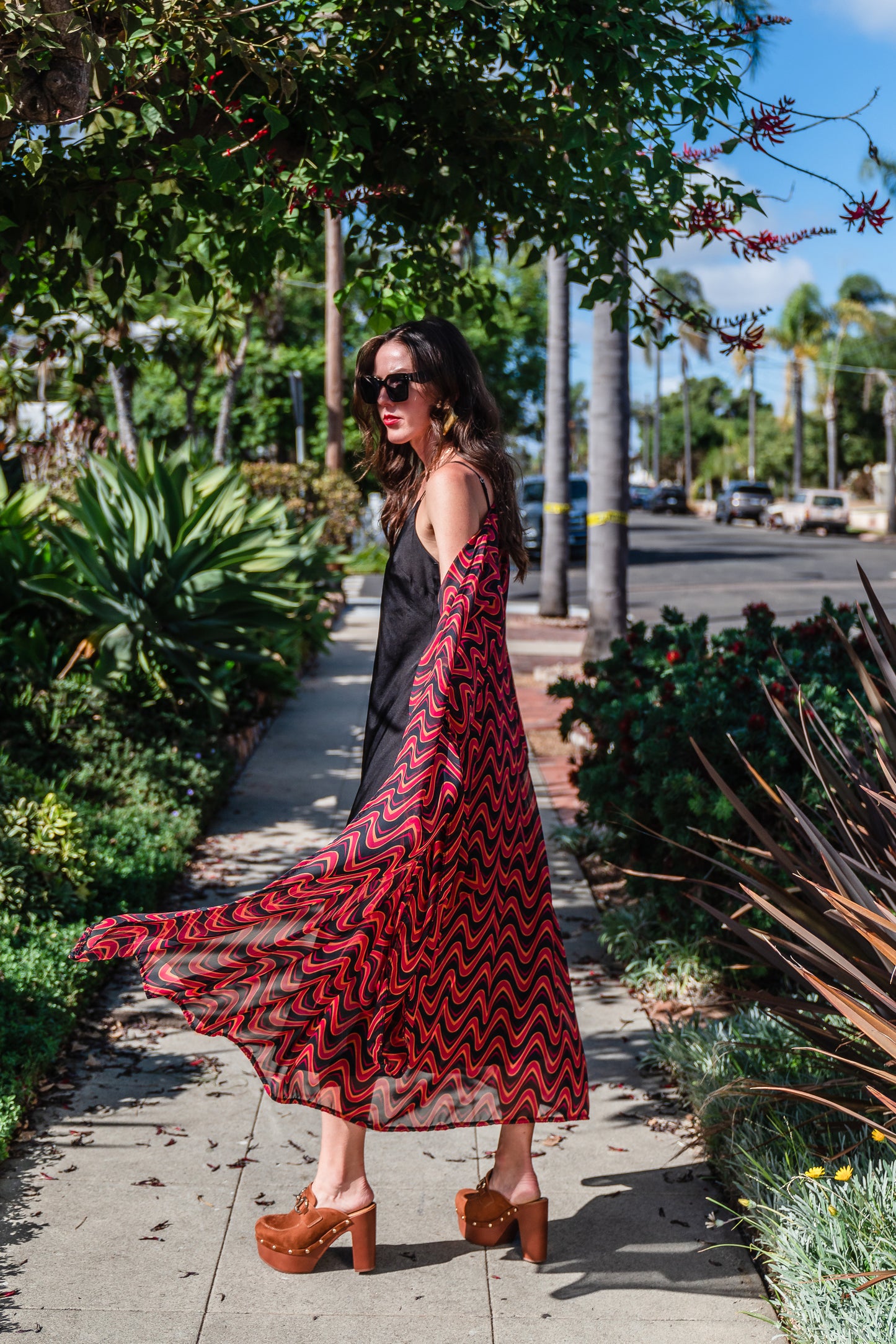 This Kimono features a futuristic spiral print in striking black and red, with a pop of orange for a modern and elegant touch.