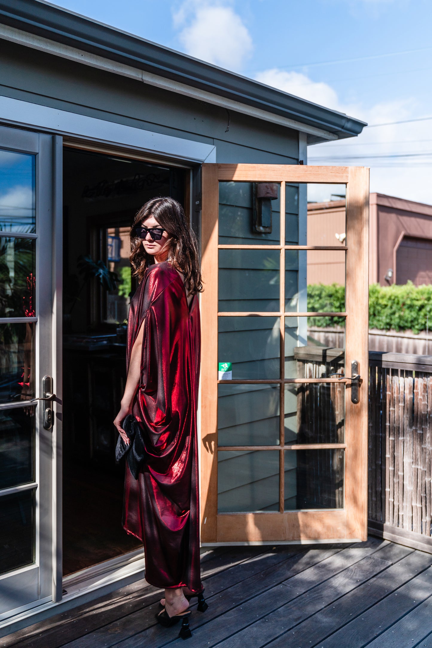 A metallic solid red caftan featuring batwing sleeves, a deep v neckline, and ankle length hem.