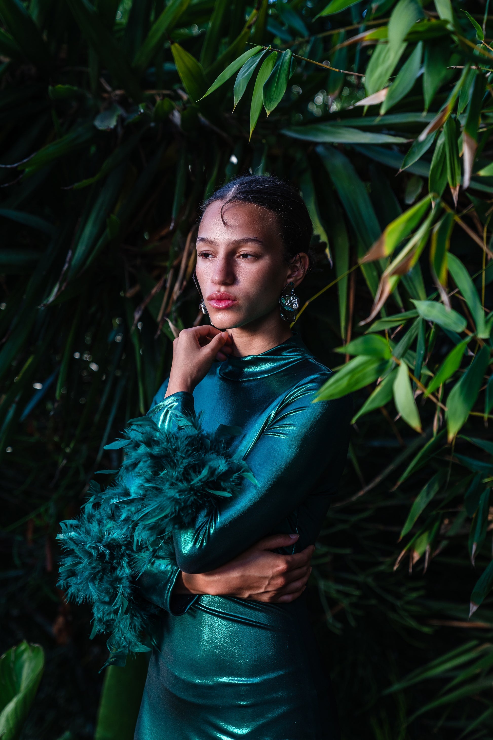 This emerald lamé, bodycon dress accentuates your curves, while the removable feather trim on the sleeves adds a touch of elegance.