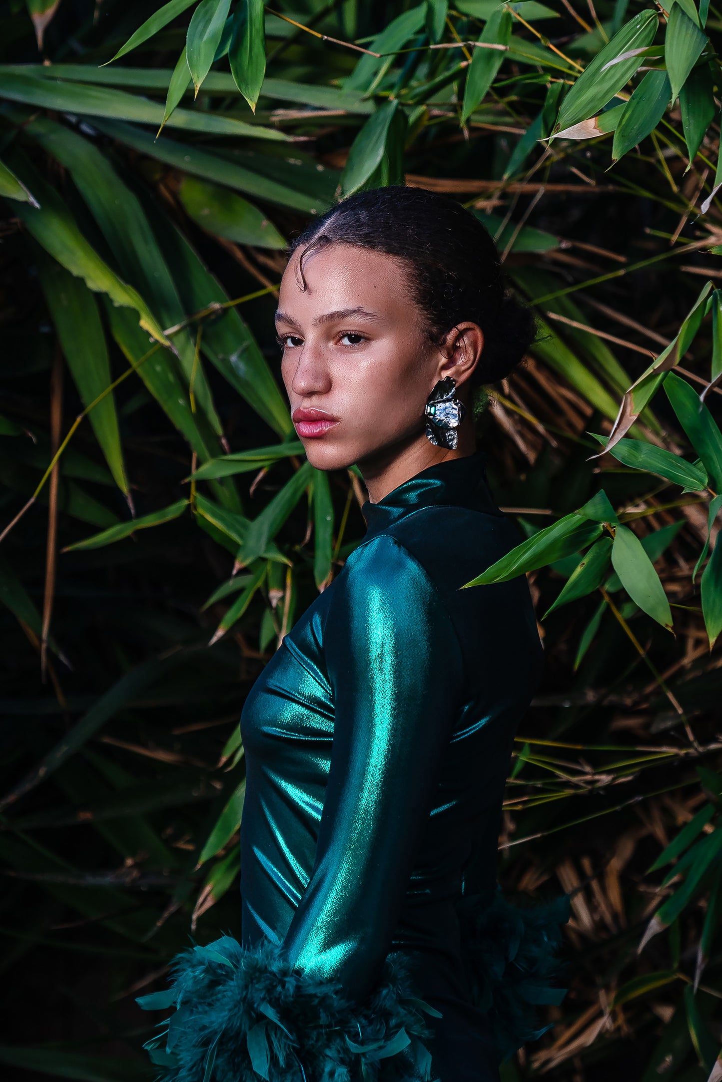 This emerald lamé, bodycon dress accentuates your curves, while the removable feather trim on the sleeves adds a touch of elegance.