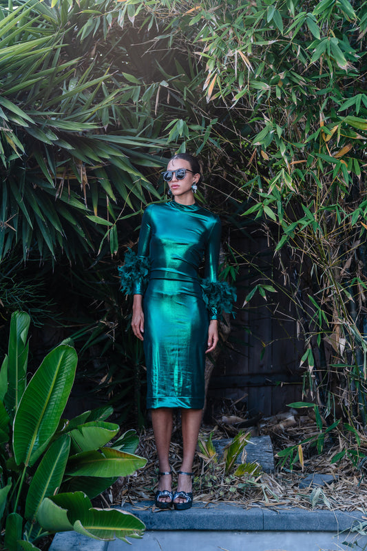 This emerald lamé, bodycon dress accentuates your curves, while the removable feather trim on the sleeves adds a touch of elegance.