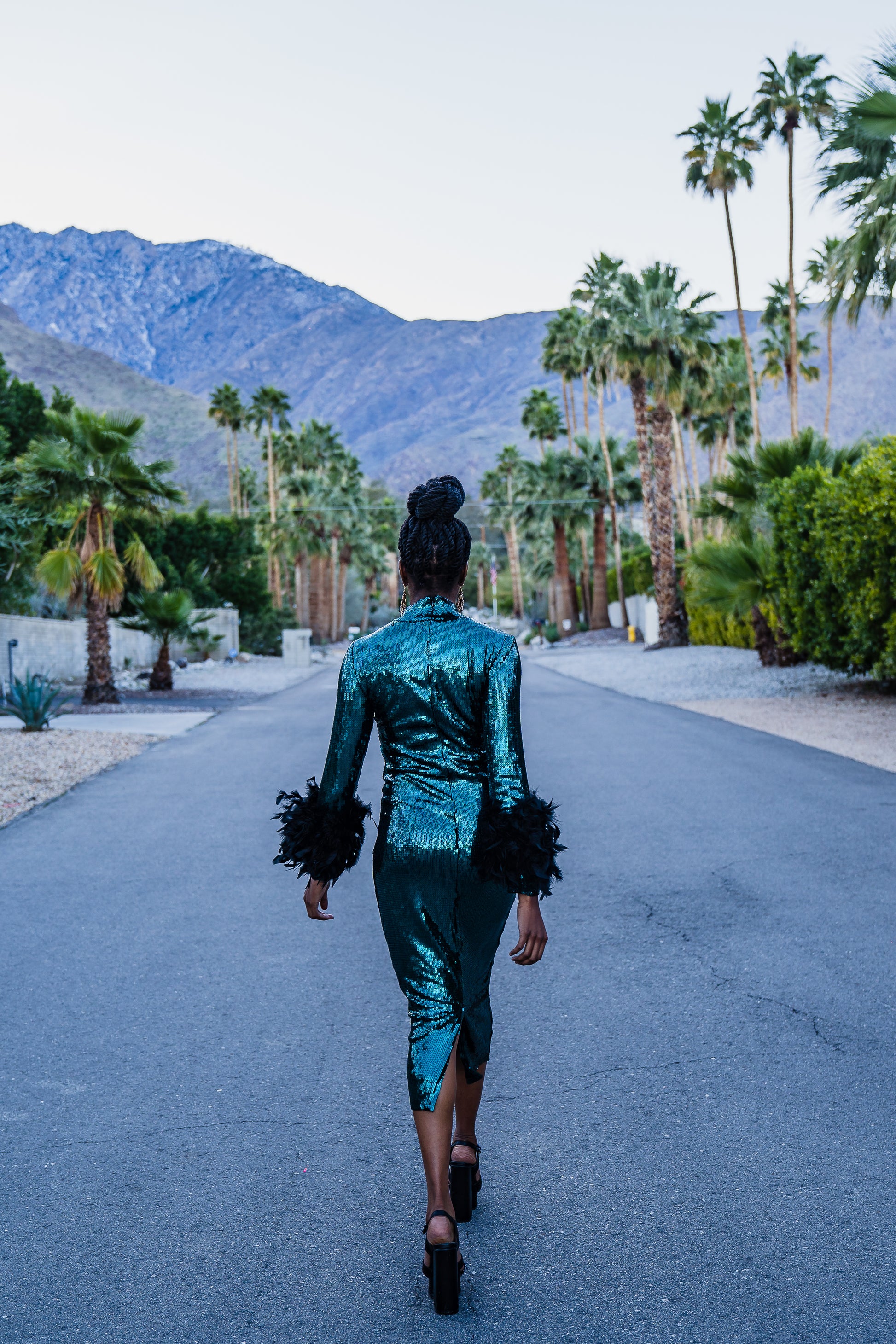 The emerald sequined, bodycon design accentuates your curves, while the removable feather trim on the sleeves adds a touch of elegance.