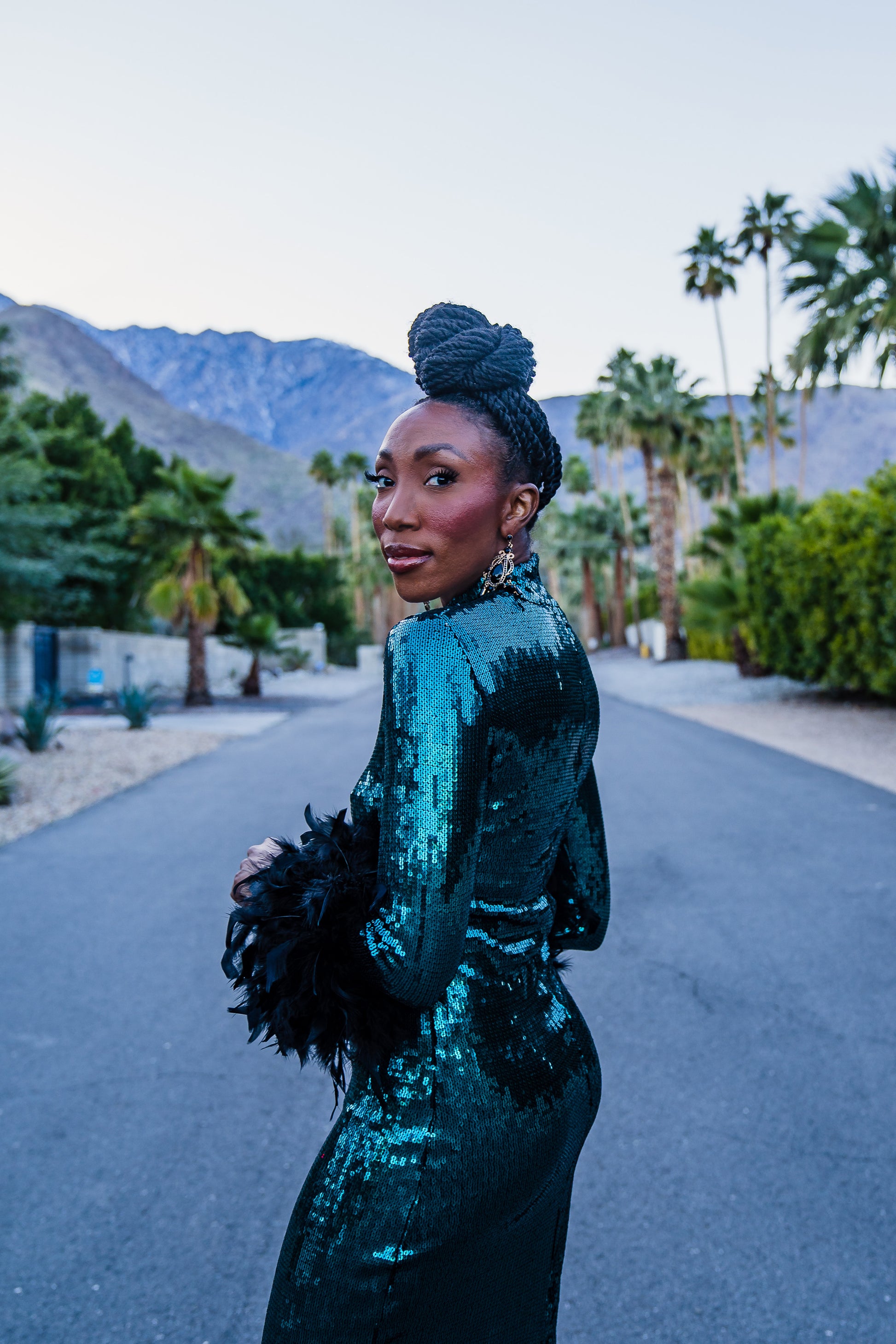 The emerald sequined, bodycon design accentuates your curves, while the removable feather trim on the sleeves adds a touch of elegance.