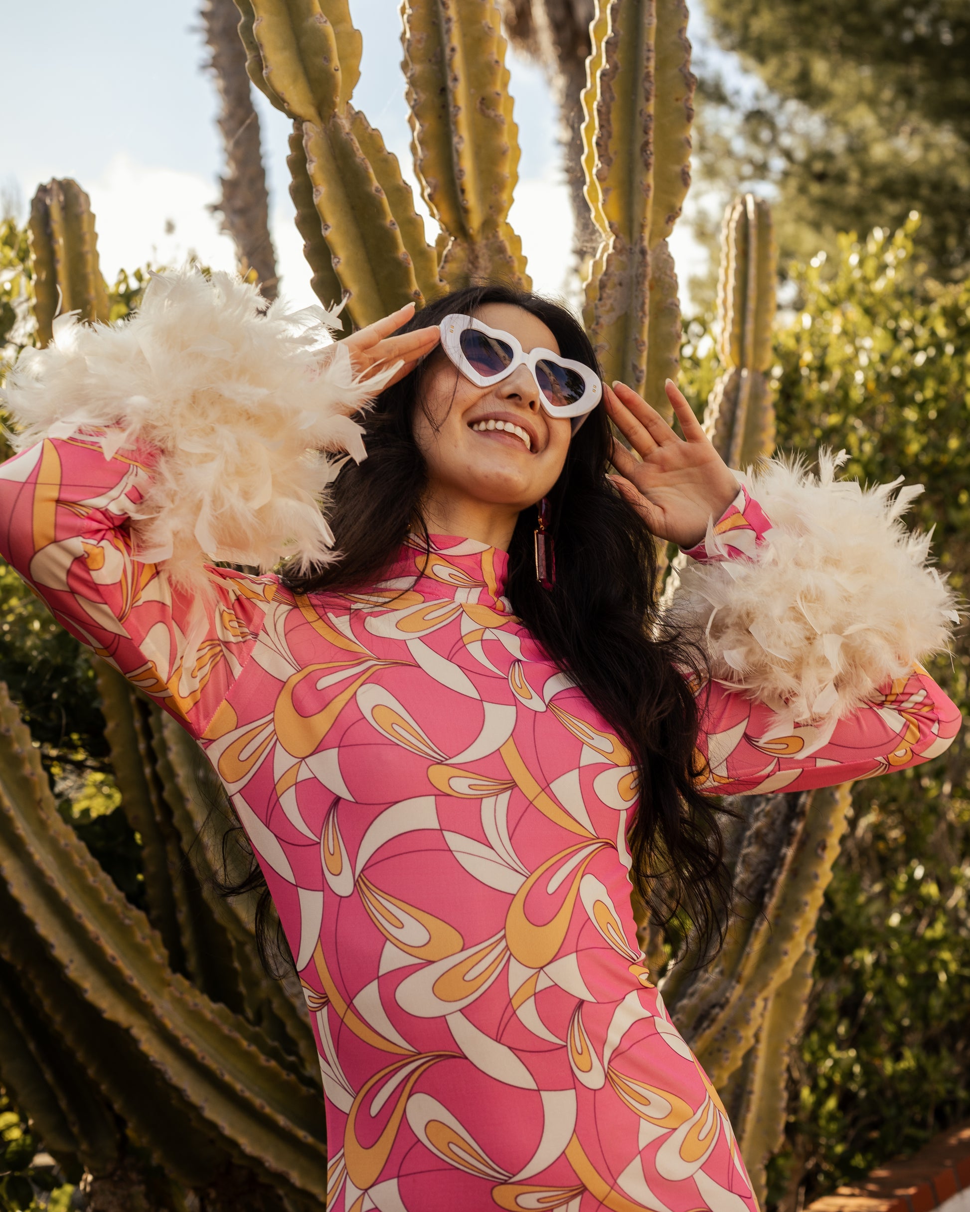 This pop-art bodycon design accentuates your curves, while the removable feather trim on the sleeves adds a touch of elegance.