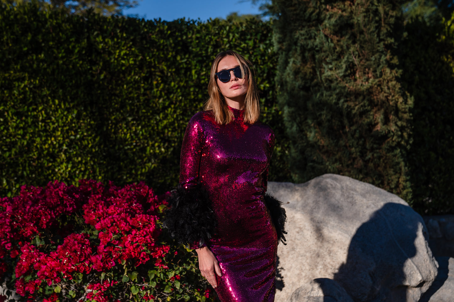 This red sequined, bodycon design accentuates your curves, while the removable feather trim on the sleeves adds a touch of elegance.