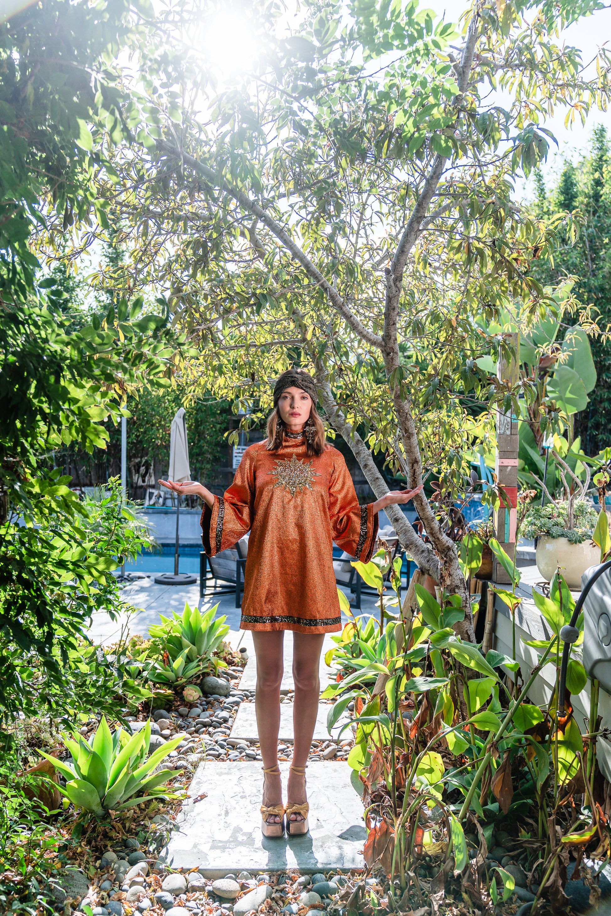 Crafted from a shimmering, fiery orange fabric embellished with an intricate sequin sun and matching sequin details at collar, cuffs, and hem, this is the bold and dreamy 60s revival romance dress every wardrobe craves
