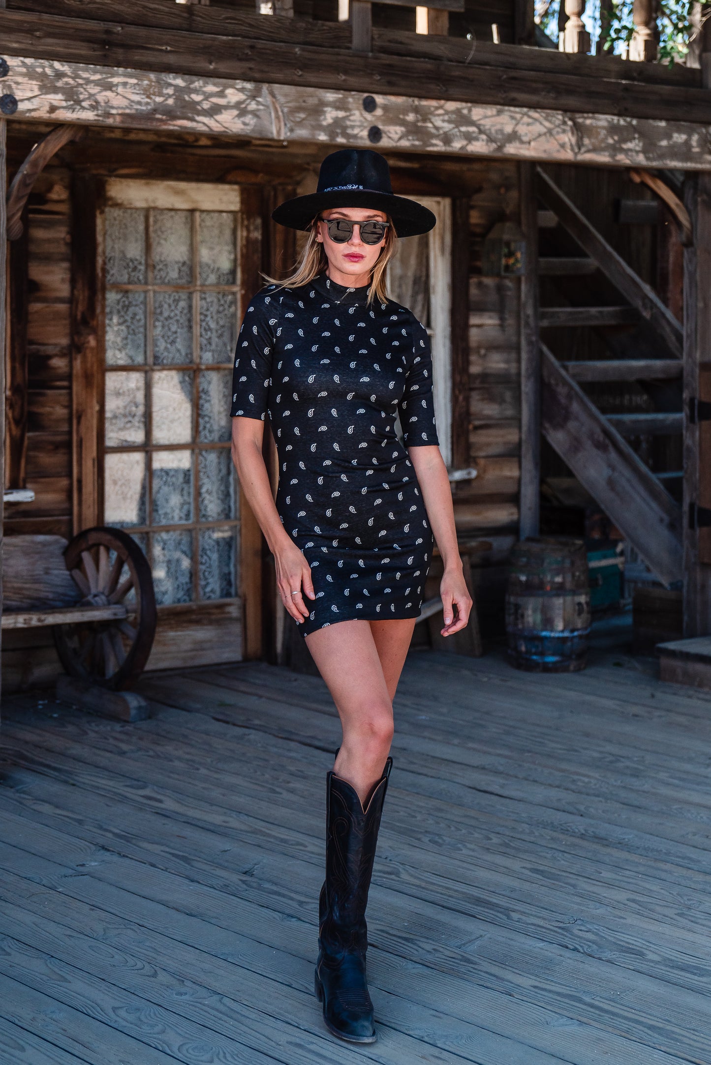 This Jennafer Grace mini dress features a black and white paisley print, elbow length short sleeves, a mock neck, and invisible zipper in back.