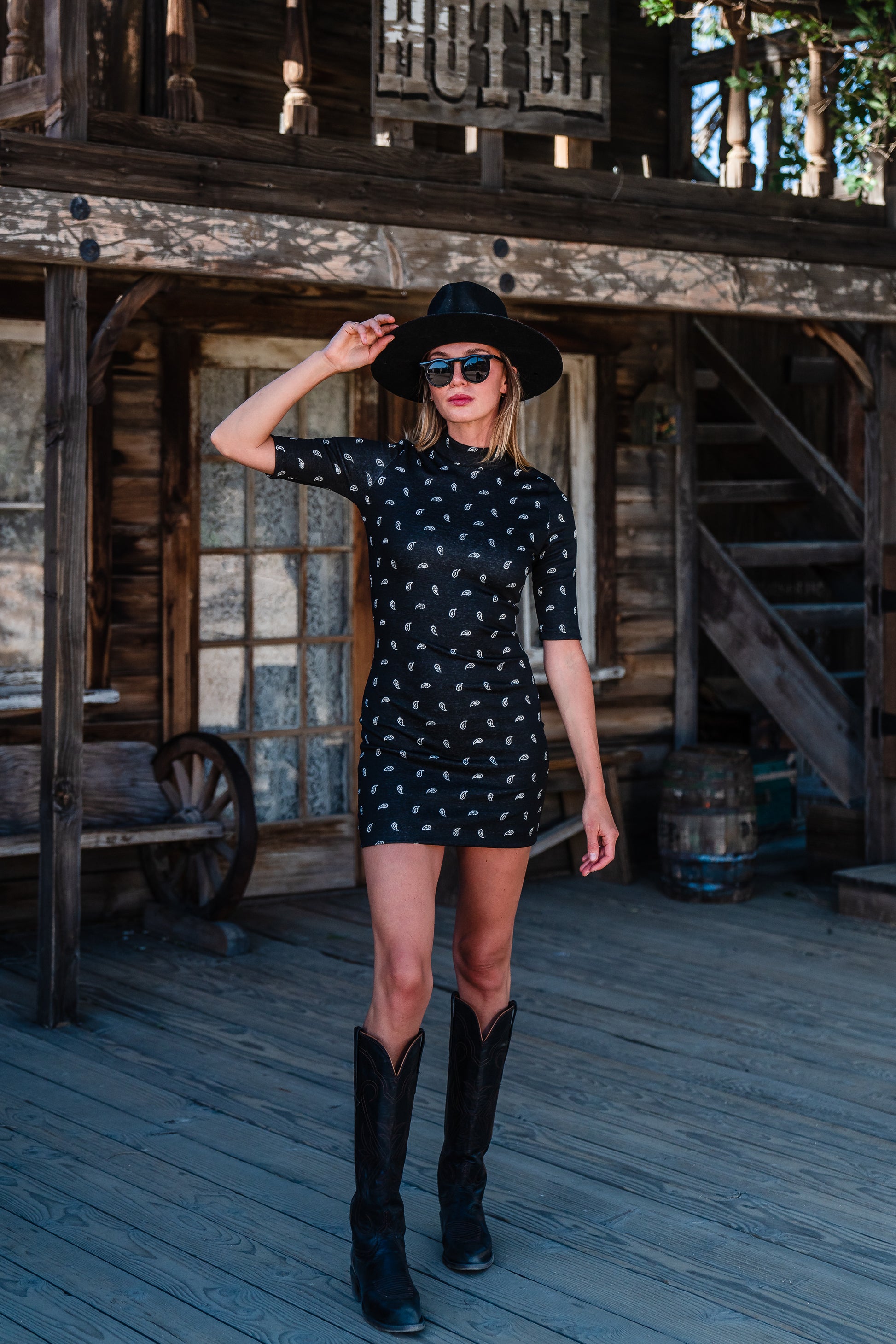 This Jennafer Grace mini dress features a black and white paisley print, elbow length short sleeves, a mock neck, and invisible zipper in back.