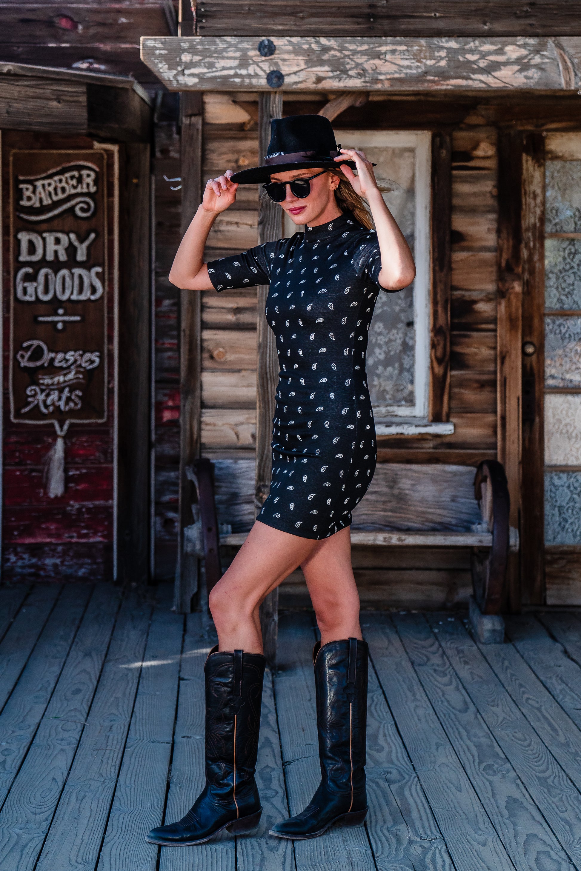 This Jennafer Grace mini dress features a black and white paisley print, elbow length short sleeves, a mock neck, and invisible zipper in back.