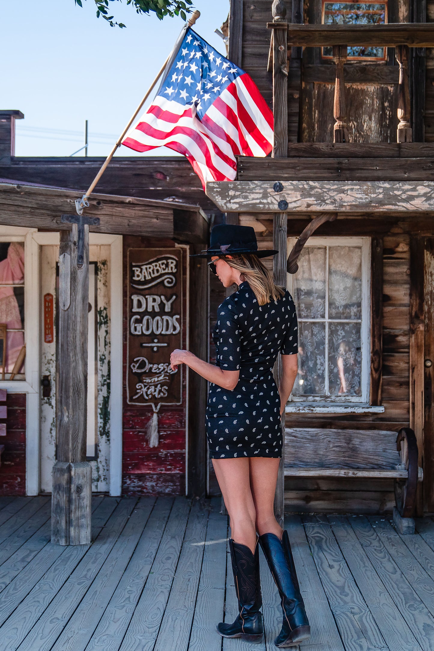 This Jennafer Grace mini dress features a black and white paisley print, elbow length short sleeves, a mock neck, and invisible zipper in back.