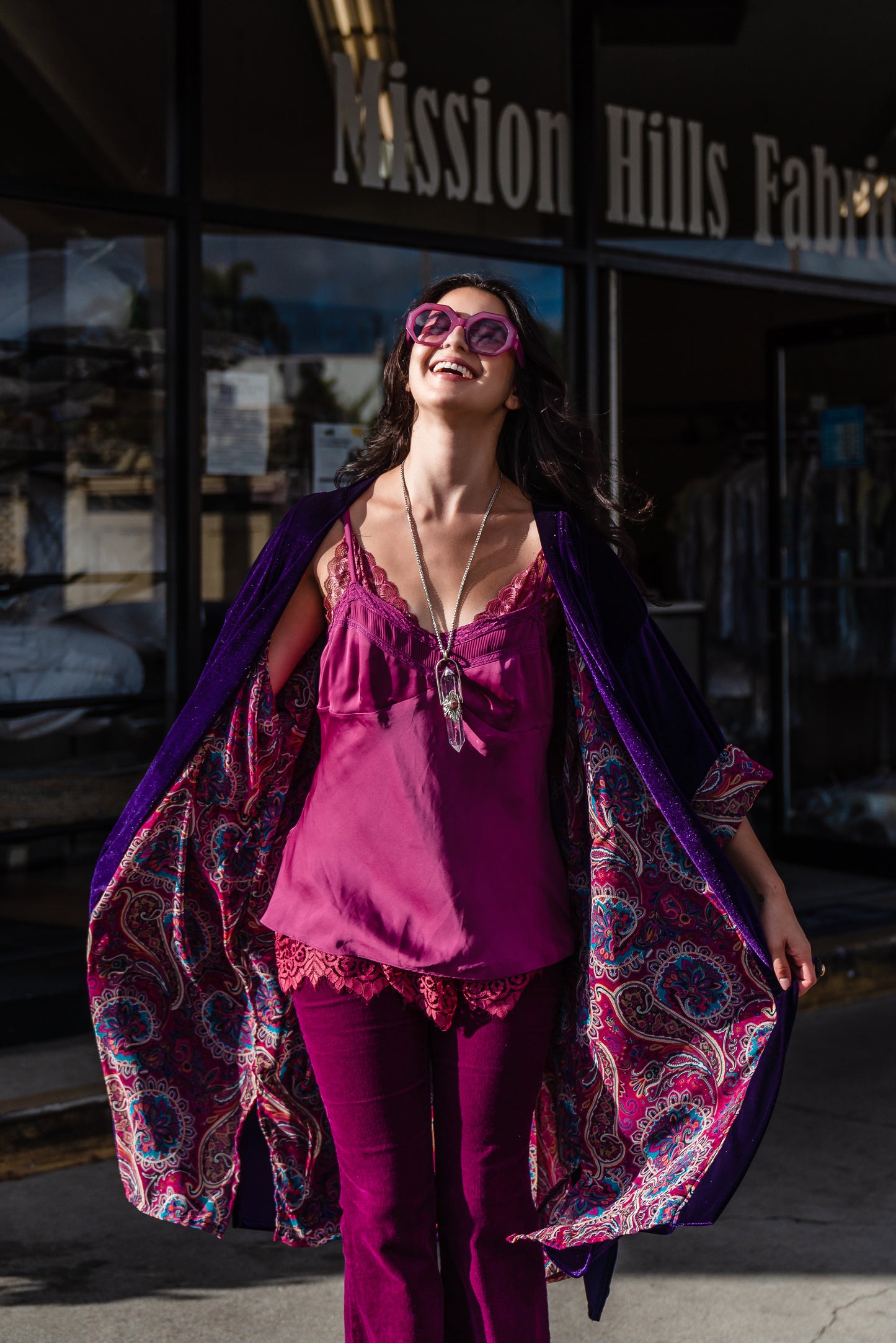 Reversible purple velvet knee length kimono with narrow sleeves, it has tie belt at the waist, the lining is pink and purple paisley printed chiffon, lining is shown at the turned up cuffs