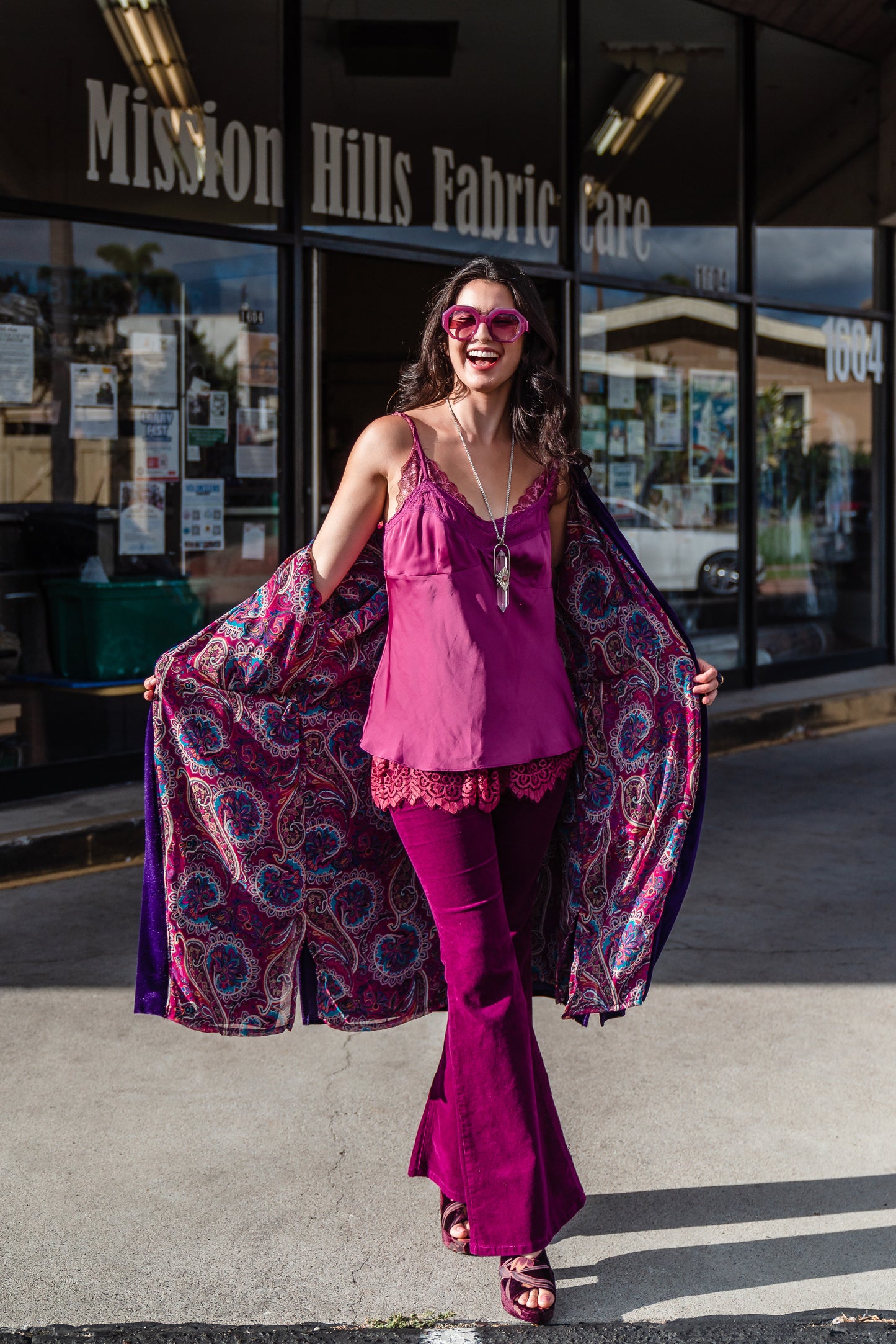 Reversible purple velvet knee length kimono with narrow sleeves, it has tie belt at the waist, the lining is pink and purple paisley printed chiffon, lining is shown at the turned up cuffs