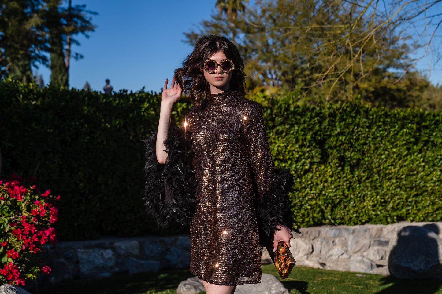 This shimmering copper flash mod mini dress has it all - glittering sequins, delicate mock neck, and long bell sleeves cuffed with black feathers. Retro 60s glam