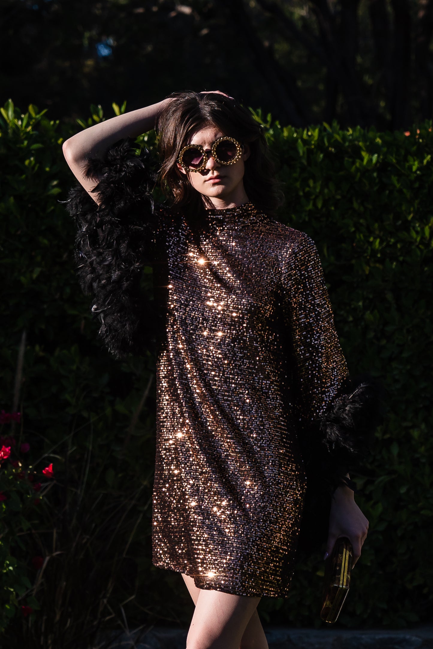 This shimmering copper flash mod mini dress has it all - glittering sequins, delicate mock neck, and long bell sleeves cuffed with black feathers. Retro 60s glam
