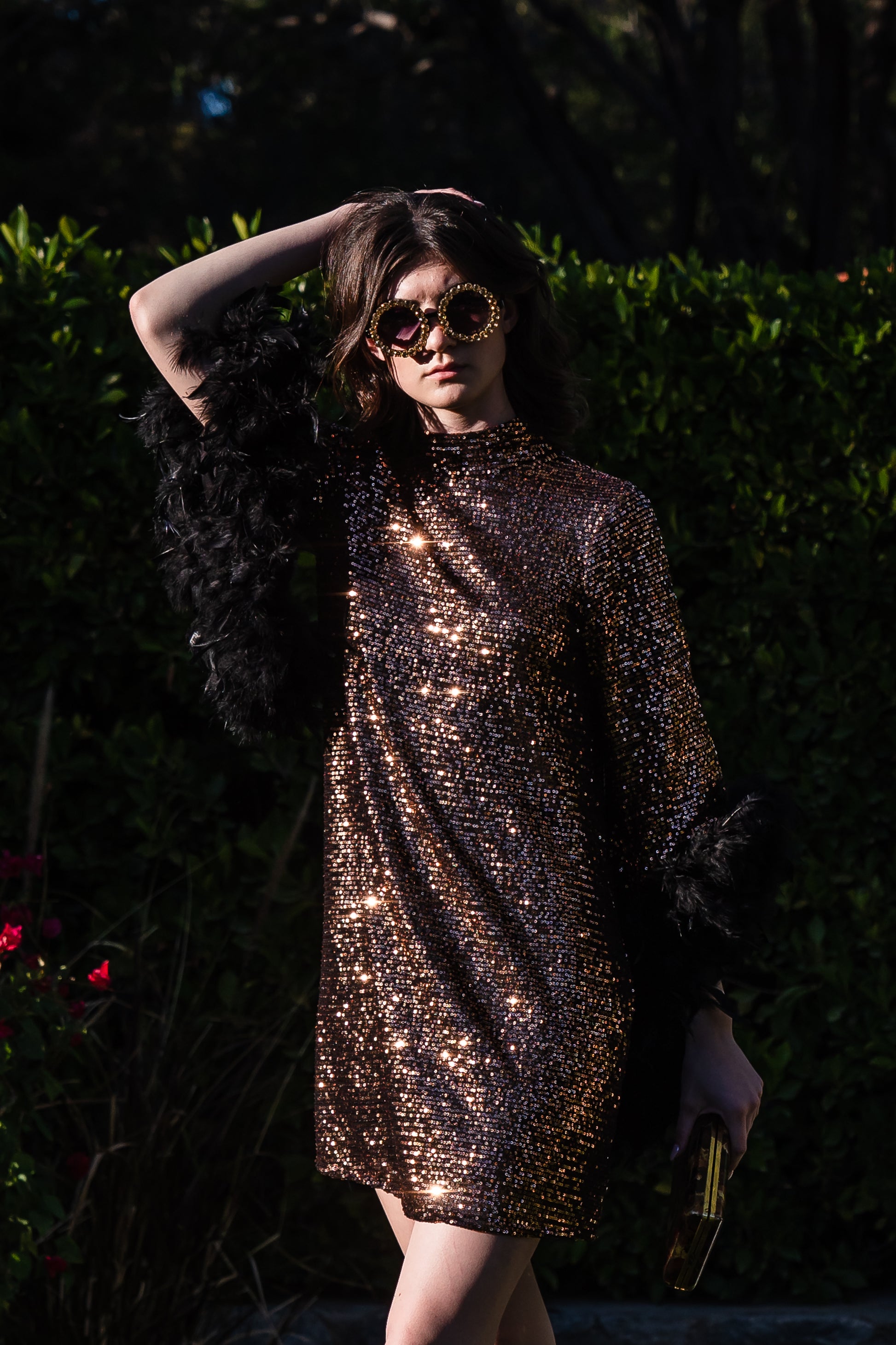 This shimmering copper flash mod mini dress has it all - glittering sequins, delicate mock neck, and long bell sleeves cuffed with black feathers. Retro 60s glam