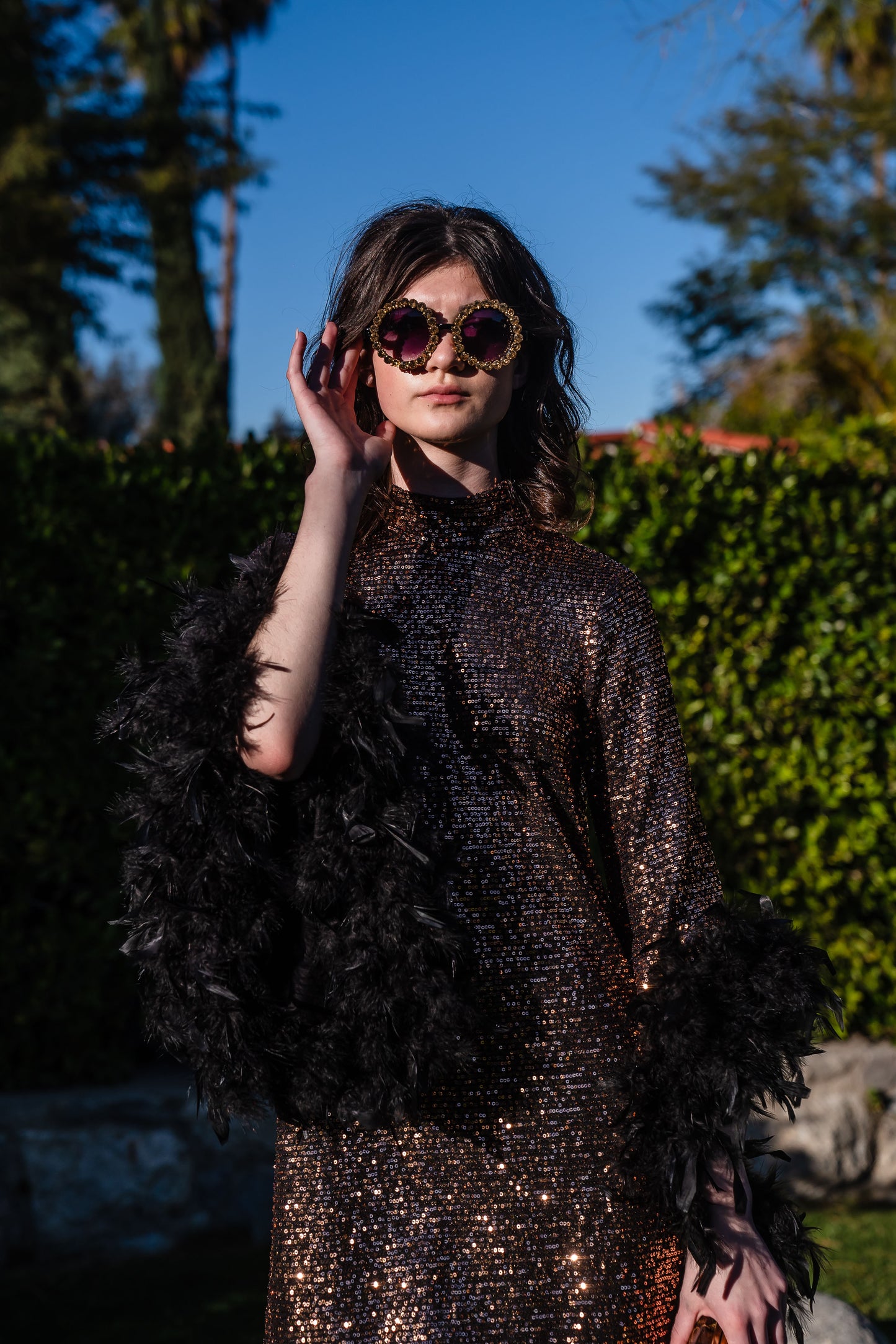 This shimmering copper flash mod mini dress has it all - glittering sequins, delicate mock neck, and long bell sleeves cuffed with black feathers. Retro 60s glam