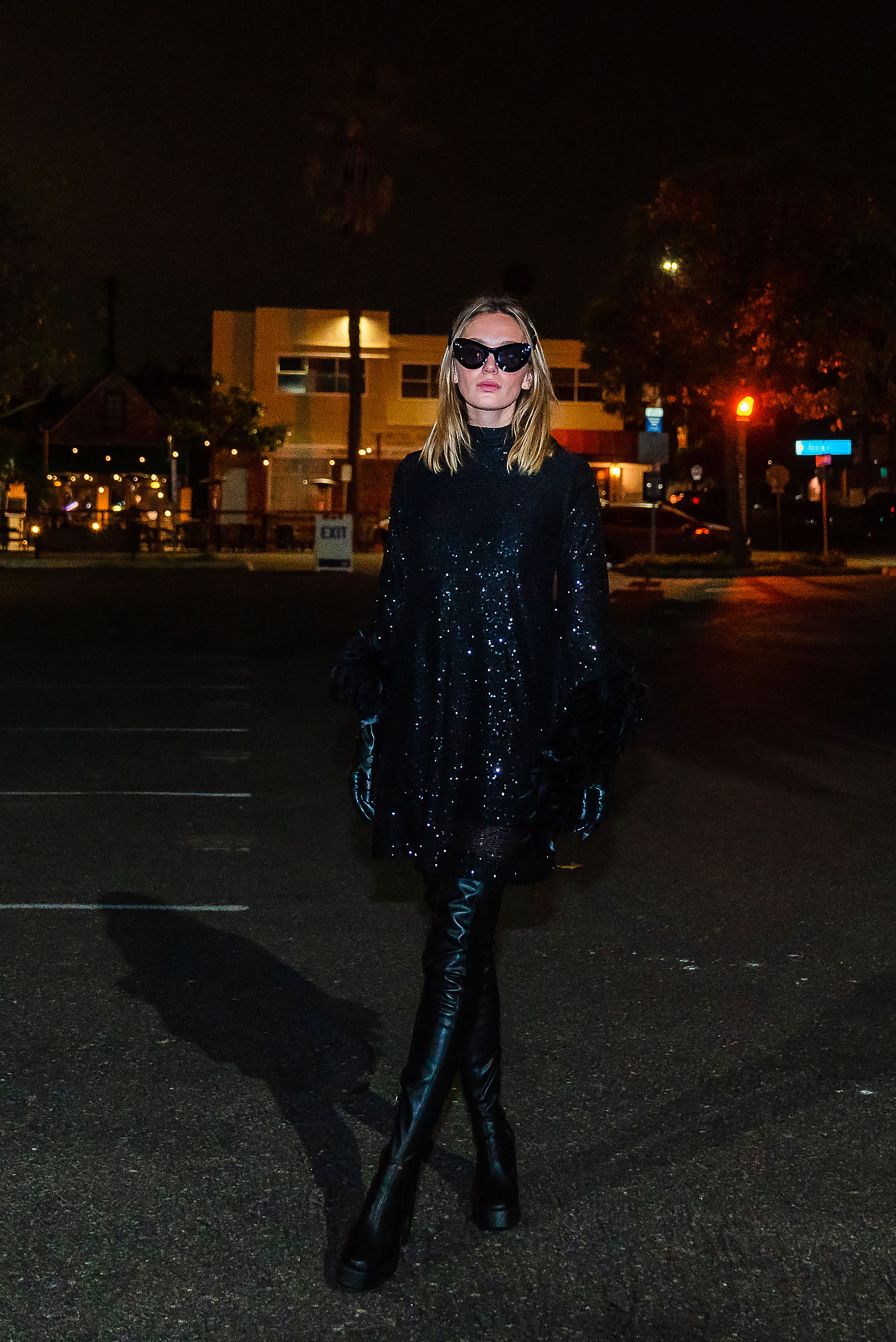 This shimmering black sequin mod mini dress has it all - glittering sequins, delicate mock neck, and long bell sleeves cuffed with black feathers