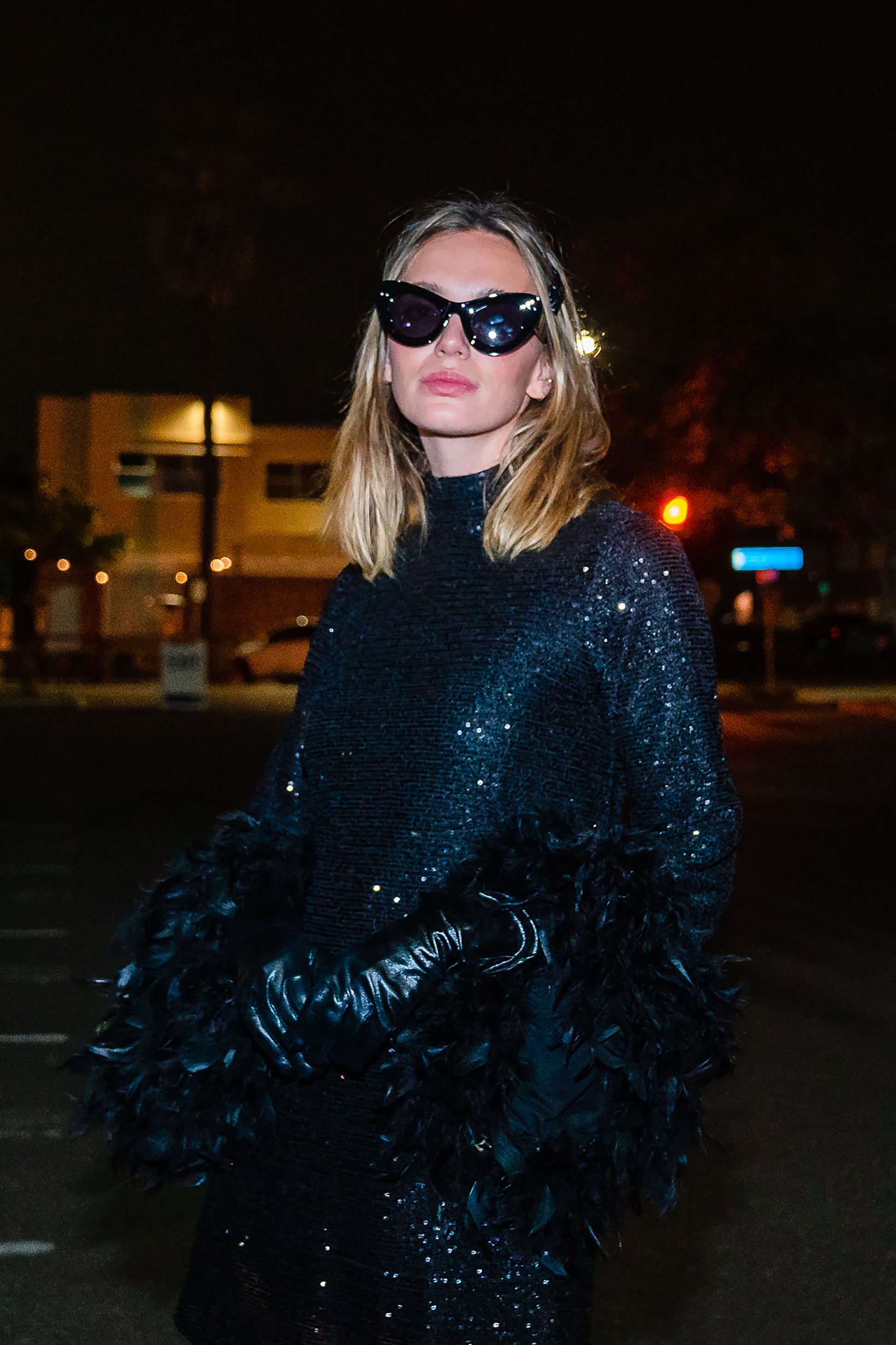 This shimmering black sequin mod mini dress has it all - glittering sequins, delicate mock neck, and long bell sleeves cuffed with black feathers