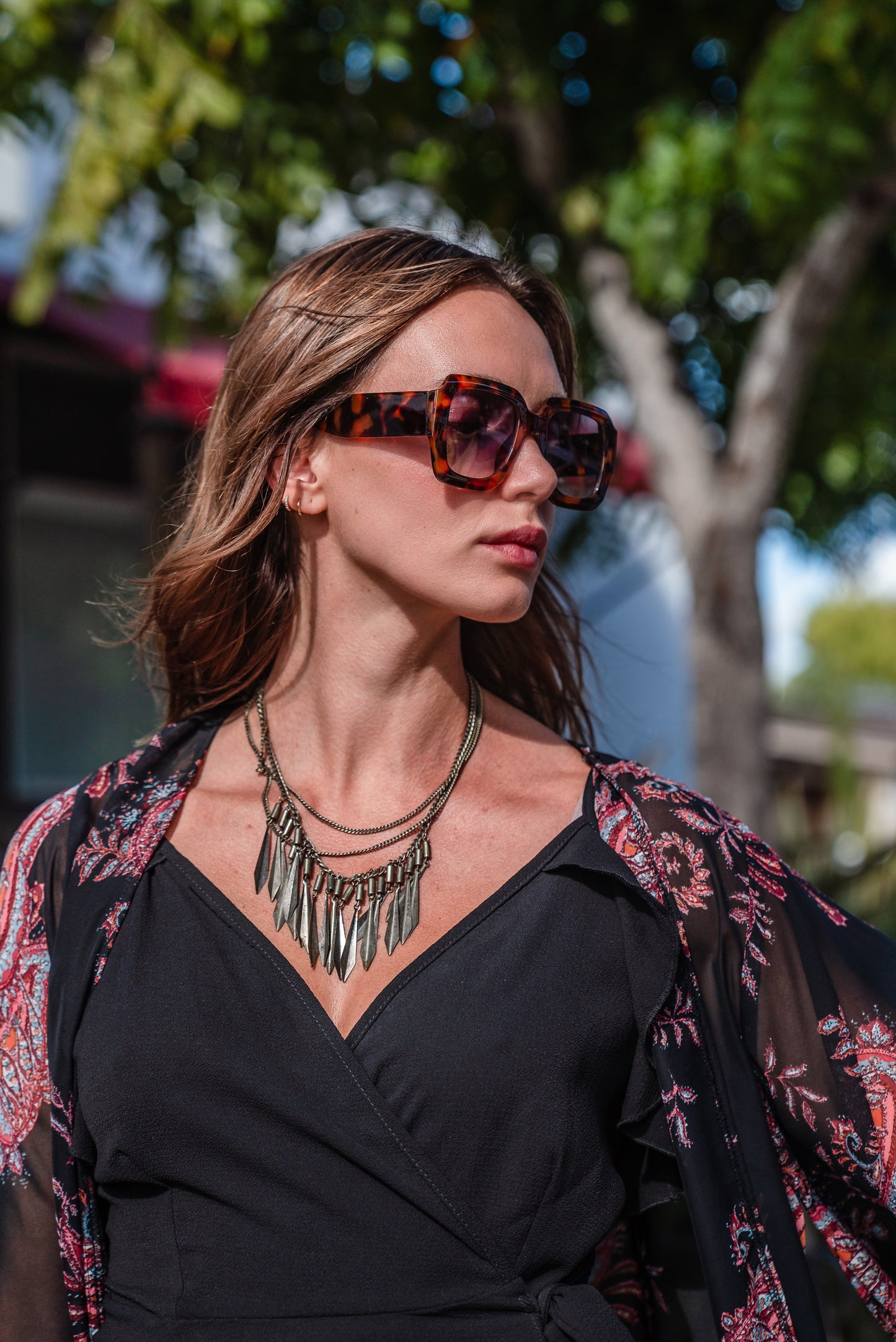 Introducing our Vera Paisley Kimono, with a black chiffon material is accented with a dark paisley pattern and pops of bordeaux, tan, and turquoise.
