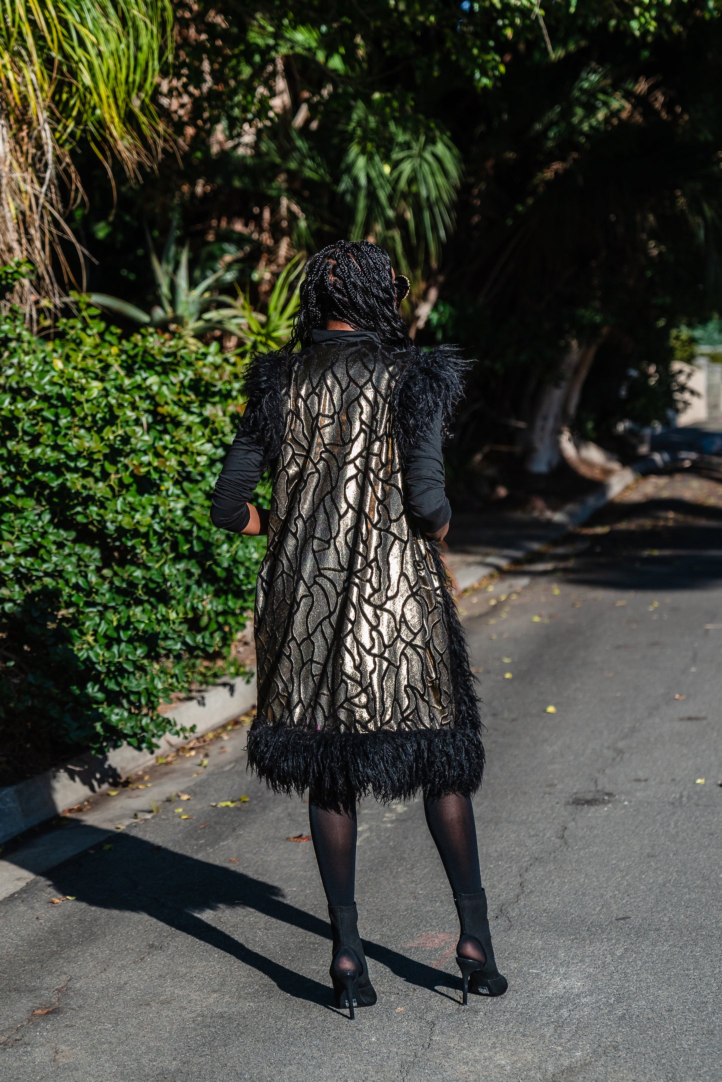 Fur Trim Vest made of shining gold waxed velvet and trimmed with black Mongolian fur. Sleeveless with knee length hem.