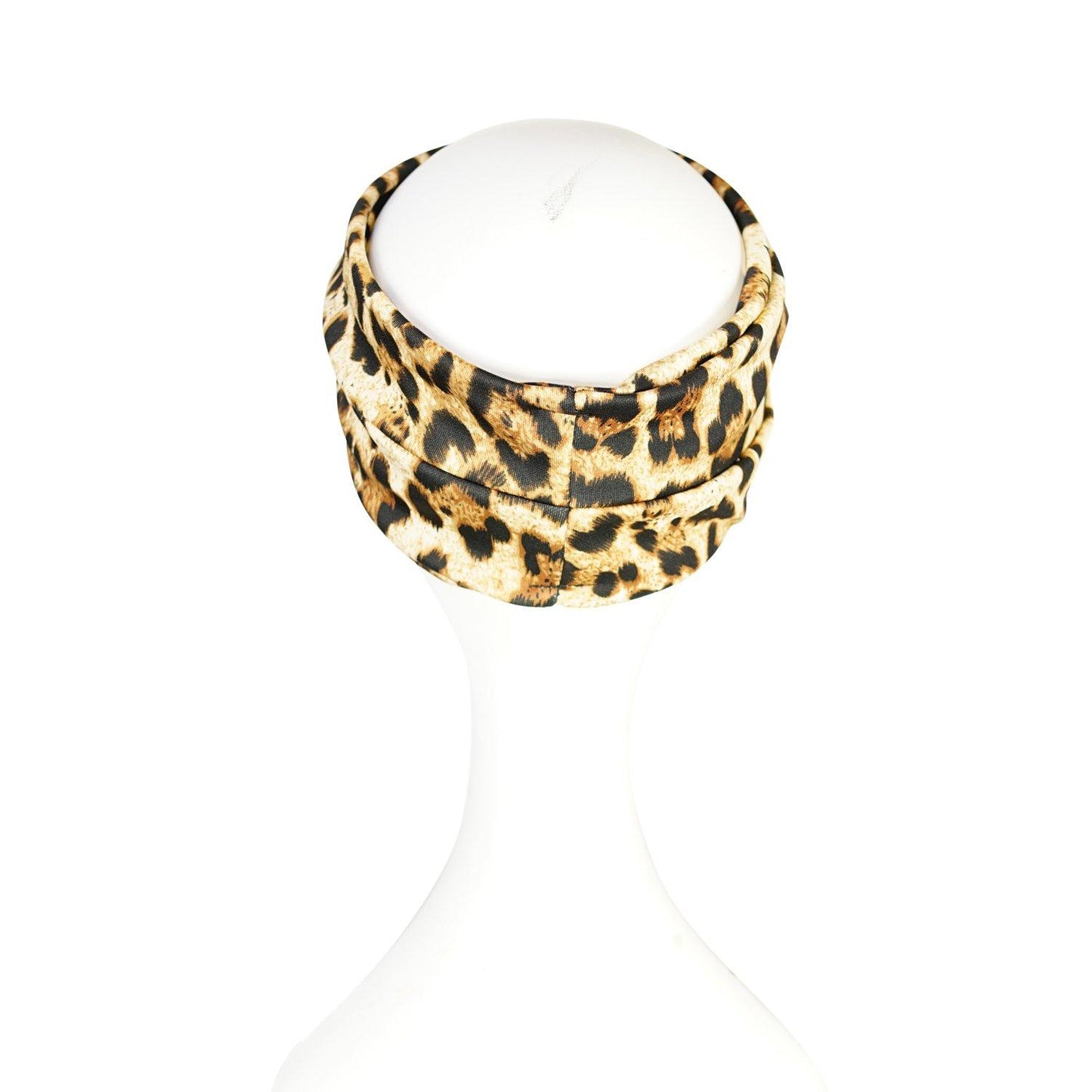 Jennafer Grace headband in leopard print. Headband is wide with twist detail in center. Easy to use to push back hair, or clip earrings on for a glamorous look.