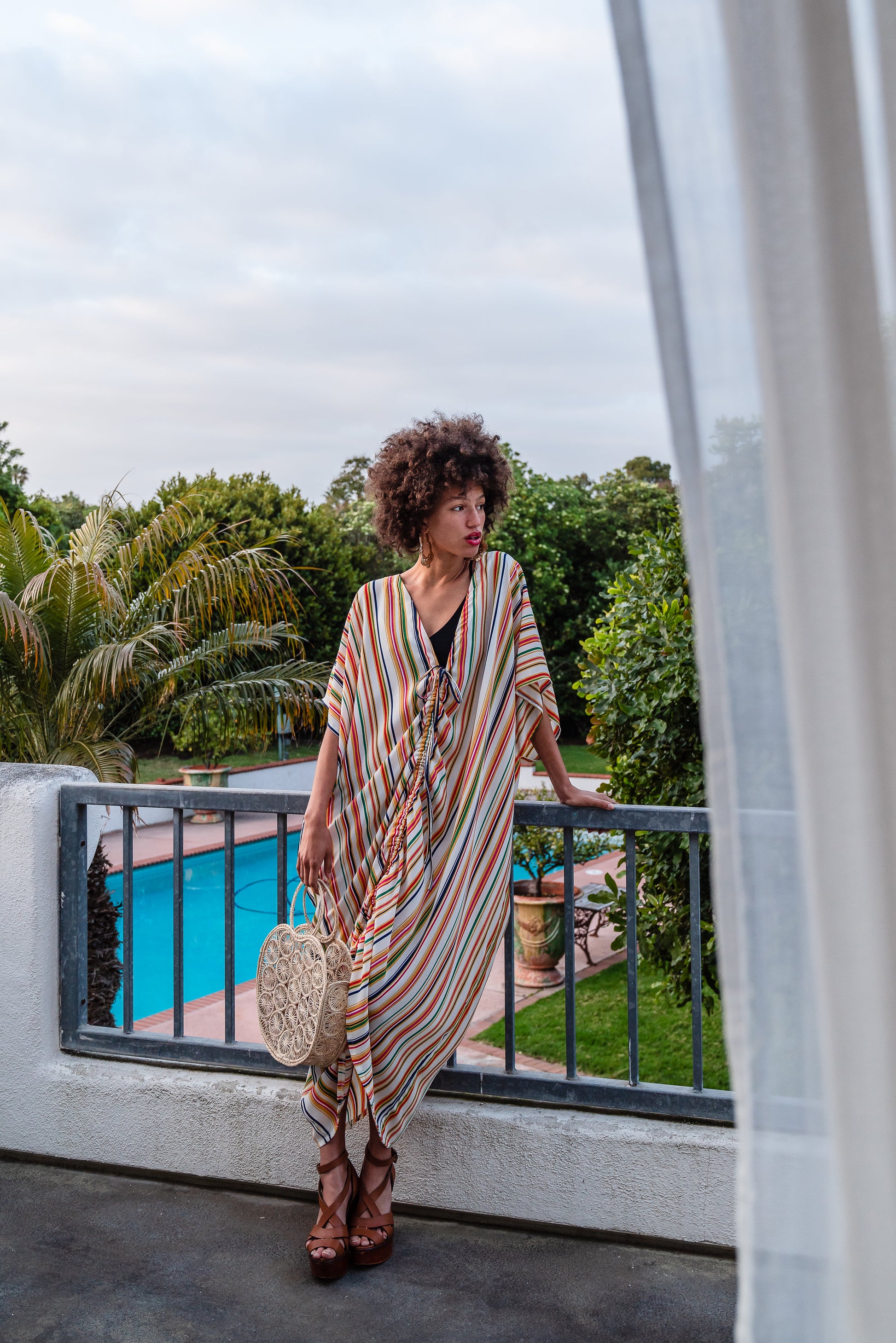 Multicolor vertical stripes on ivory chiffon caftan. This piece features a deep v-neck, batwing sleeve, a center drawstring for ruche styling, and ankle length hem. Retro bohemian aesthetic.