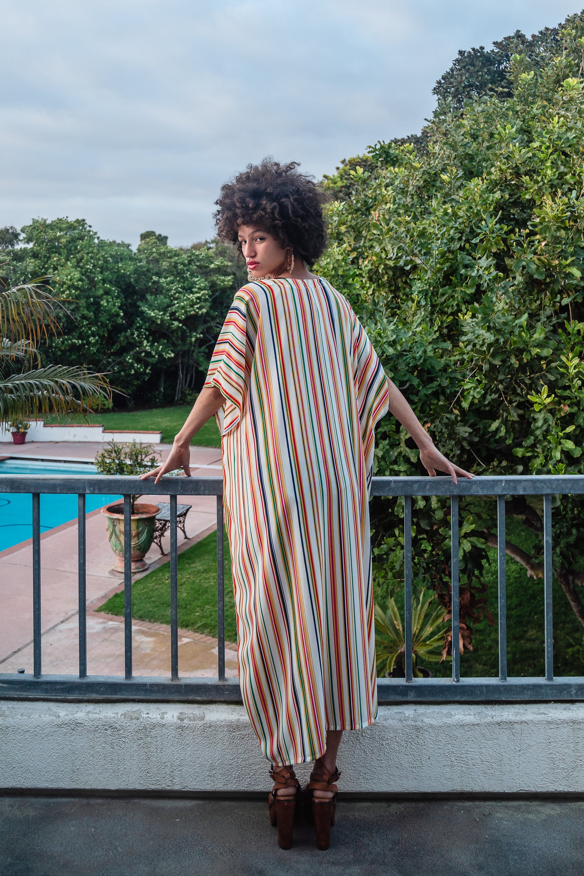 Multicolor vertical stripes on ivory chiffon caftan. This piece features a deep v-neck, batwing sleeve, a center drawstring for ruche styling, and ankle length hem. Retro bohemian aesthetic.