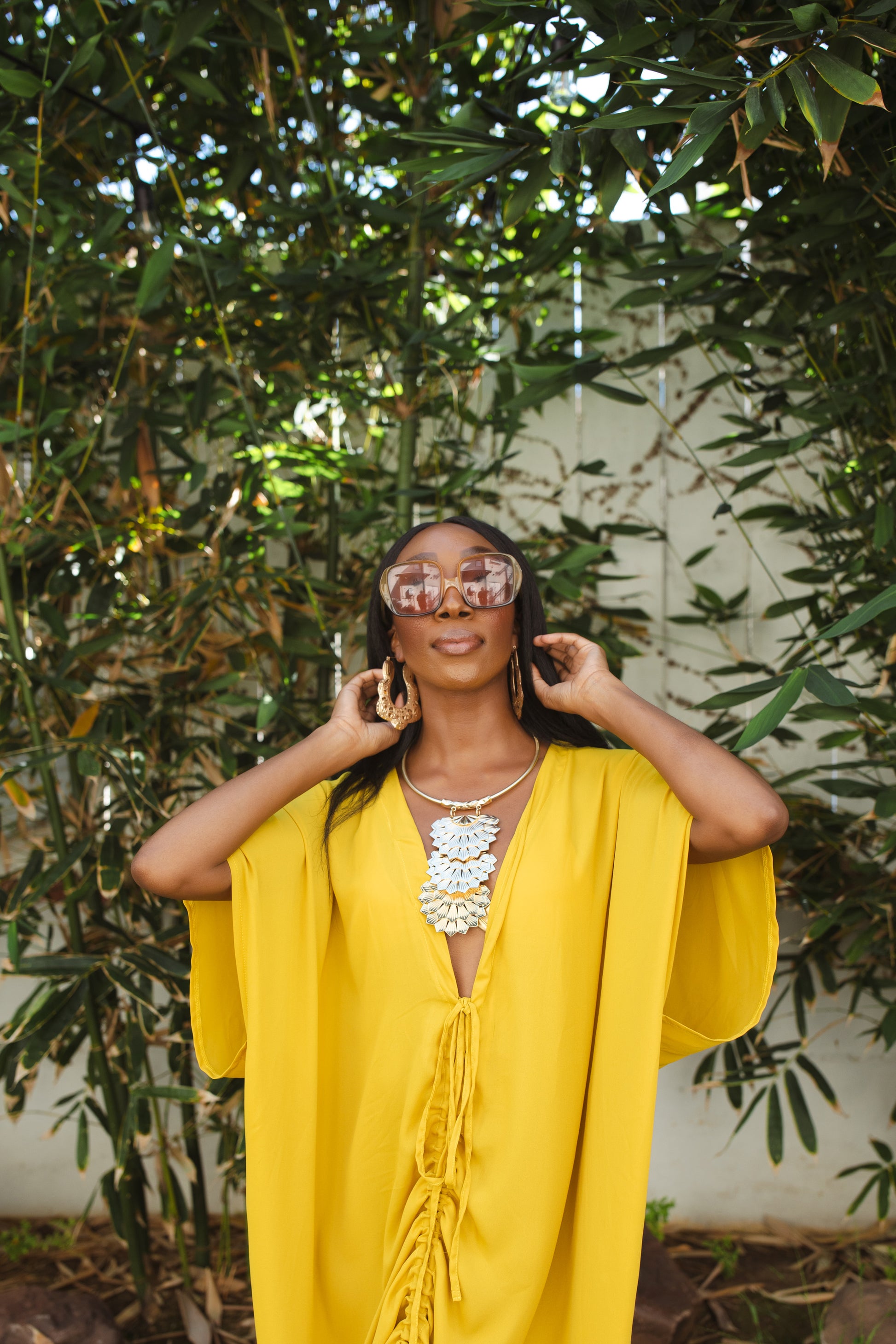 Vibrant yellow caftan. This piece features a deep v-neck, batwing sleeve, a center drawstring for ruche styling, and ankle length hem. Retro bohemian aesthetic.