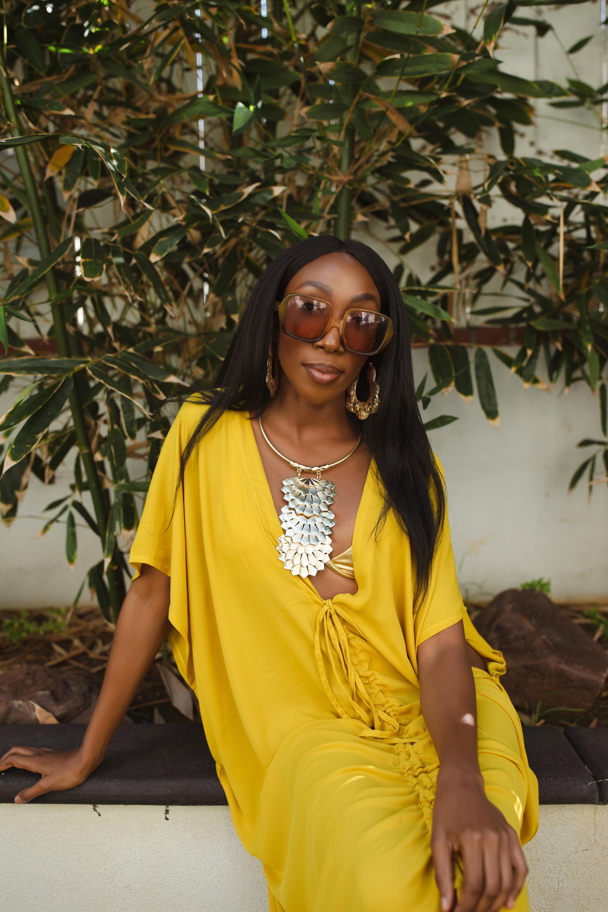 Vibrant yellow caftan. This piece features a deep v-neck, batwing sleeve, a center drawstring for ruche styling, and ankle length hem. Retro bohemian aesthetic.