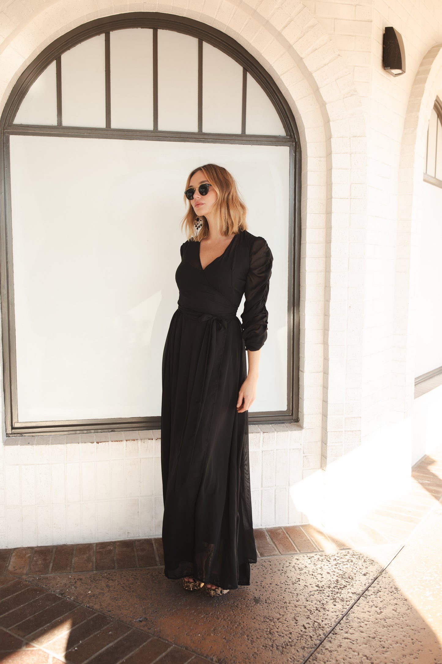 Semi-sheer black maxi dress. The dress features a wrap front, v-neck, three-quarter sleeve with ruching detail, and a matching black slip dress underneath. Classic, vintage inspired black maxi dress with a gothic flair.