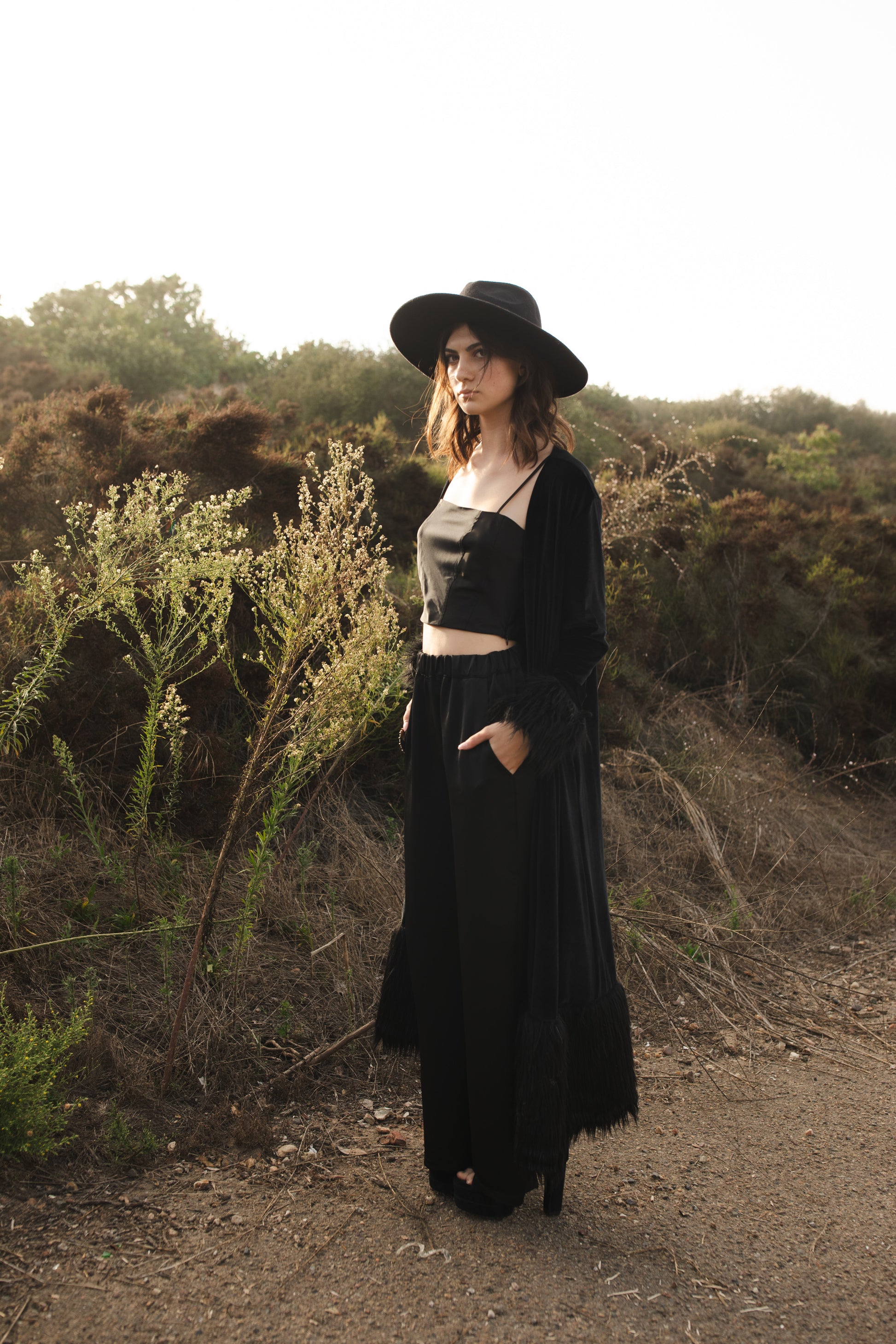 This luscious floor length Jennafer Grace coat is made with a black stretch velvet fabric featuring black faux fur cuffs at end of sleeves and base hem. It also features in-seam pockets and a super soft bamboo jersey lining. Designed and crafted in southern California.