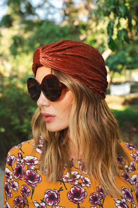 Dark rust, burnt sienna, ribbed stretch velvet fashion turban hat that wears similar to a beanie, with ruching of the fabric that meets front and center at an elegant knot. Vintage-inspired retro 1920s mixed with a modern fabric.