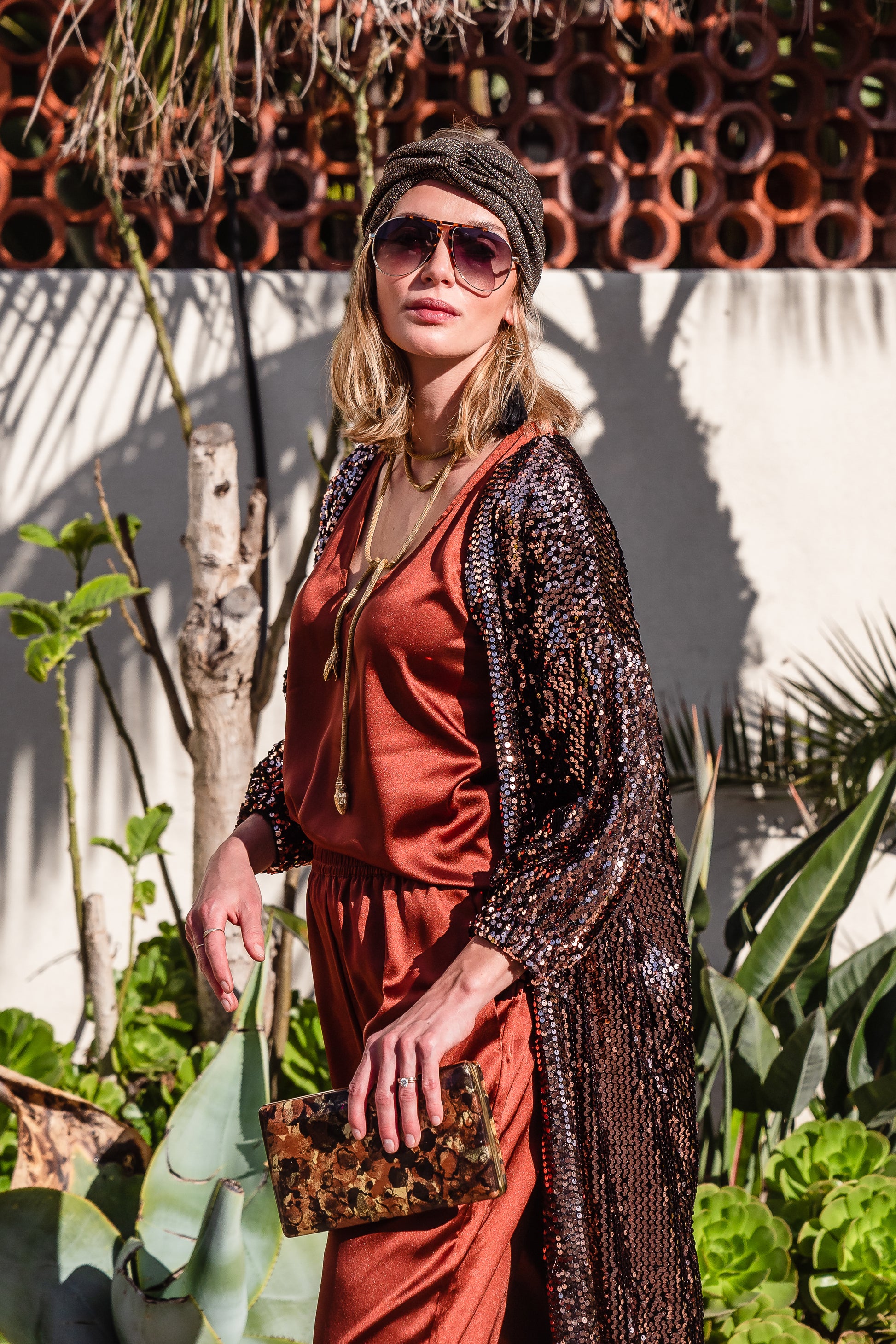 Ultra glamorous shimmering sequined cocoon jacket made from a soft black velvet inlaid with deep copper sequins and lined with soft black jersey. Featuring cocoon sleeves and pockets with a mid-shin hem.