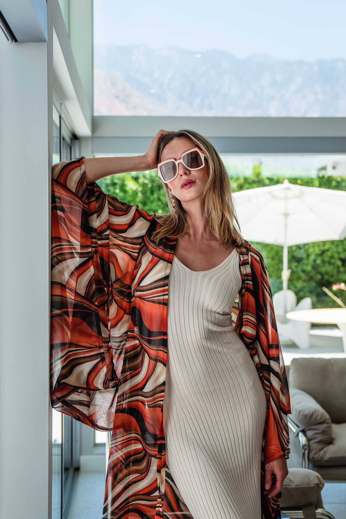 Inspired by the River Styx, the Styx Kimono is a fiery and versatile addition to your wardrobe. Made from chiffon, its abstract geometric design in shades of orange, red, and brown adds a touch of elegance to any outfit.