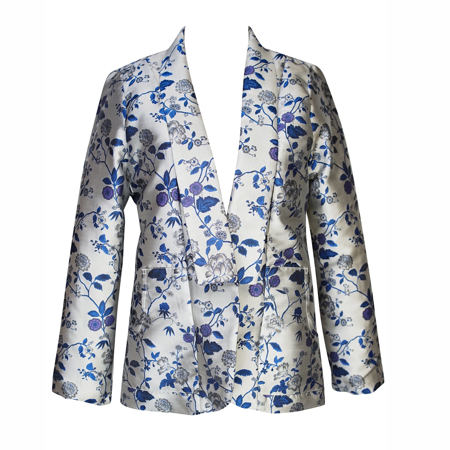 This cool-toned blazer features a silver and blue floral print with a shawl collar and pockets. Sleeve hem is slightly cropped above wrists. 