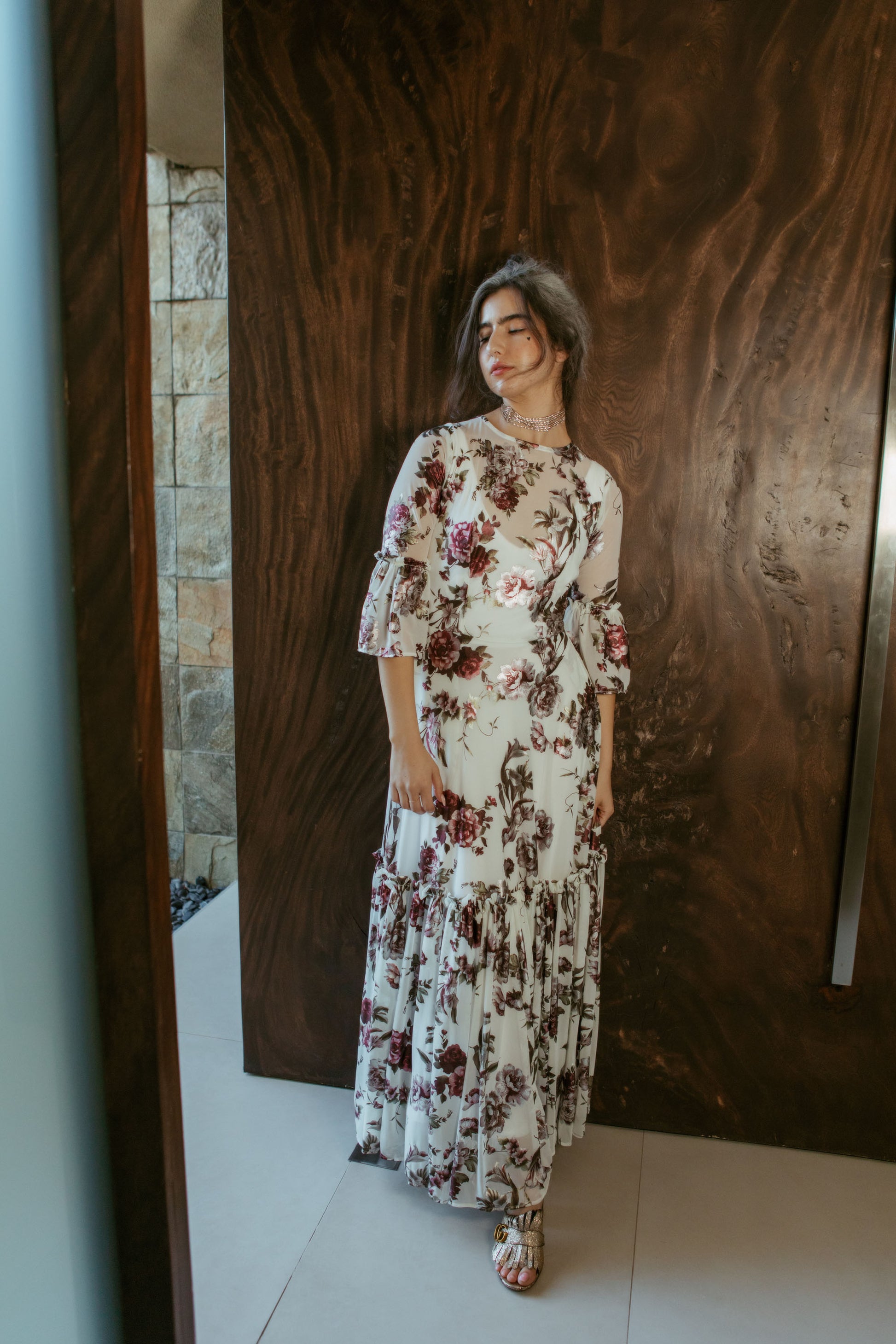 An airy ruffled maxi dress. Made with an airy and metallic detail floral mesh fabric featuring pockets, mid-length bell sleeves, and a full, single-tiered skirt with ankle hem. Includes a matching slip dress that can be worn on its own.