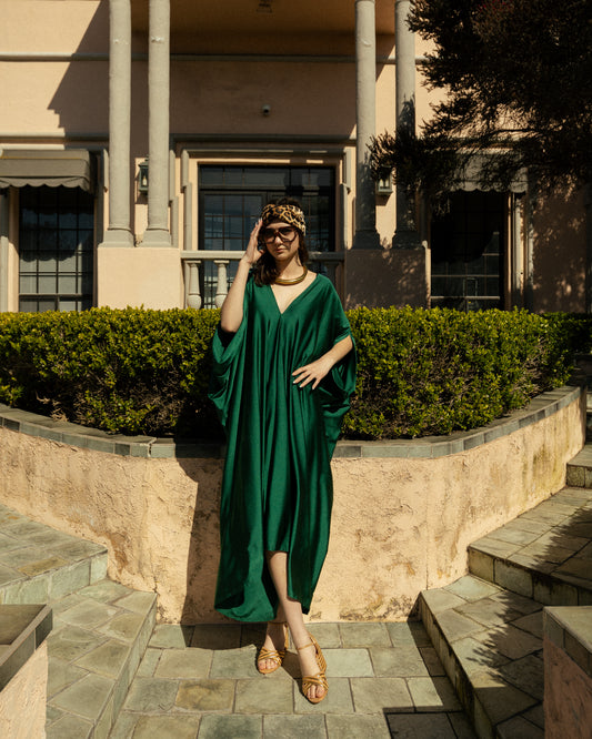 Elegant emerald green caftan made from jersey. Features a v-neck, batwing sleeves, and ankle hem.
